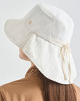 White sun hat worn by a person on a light gray background
