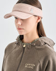 Woman wearing a beige visor and brown hoodie with 'LANVIN BLANC' branding on a light gray background
