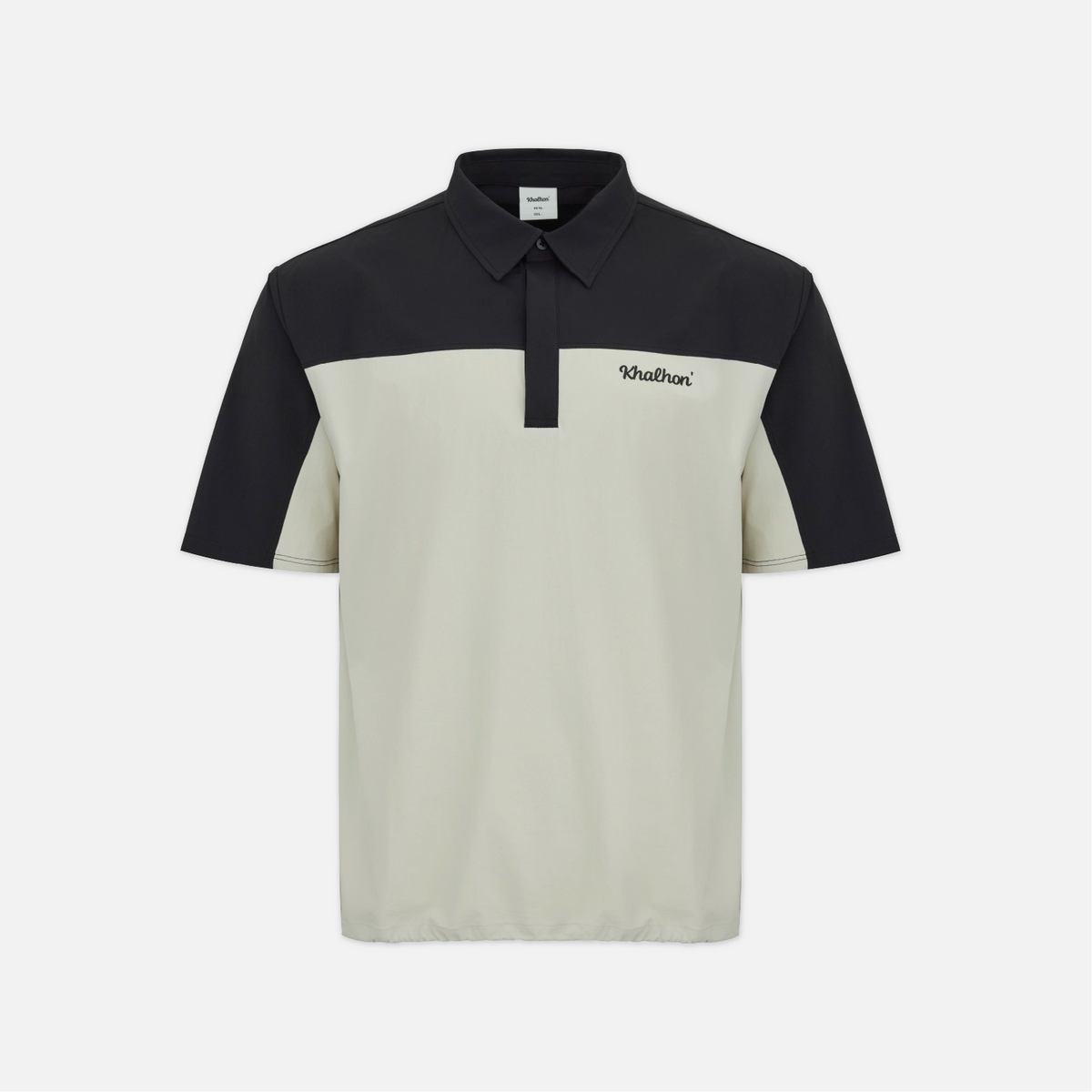 A short-sleeve polo shirt with a colorblock design, featuring a black yoke and collar, and a light beige body and sleeves. The brand name 'Wathani' is embroidered on the left chest.
