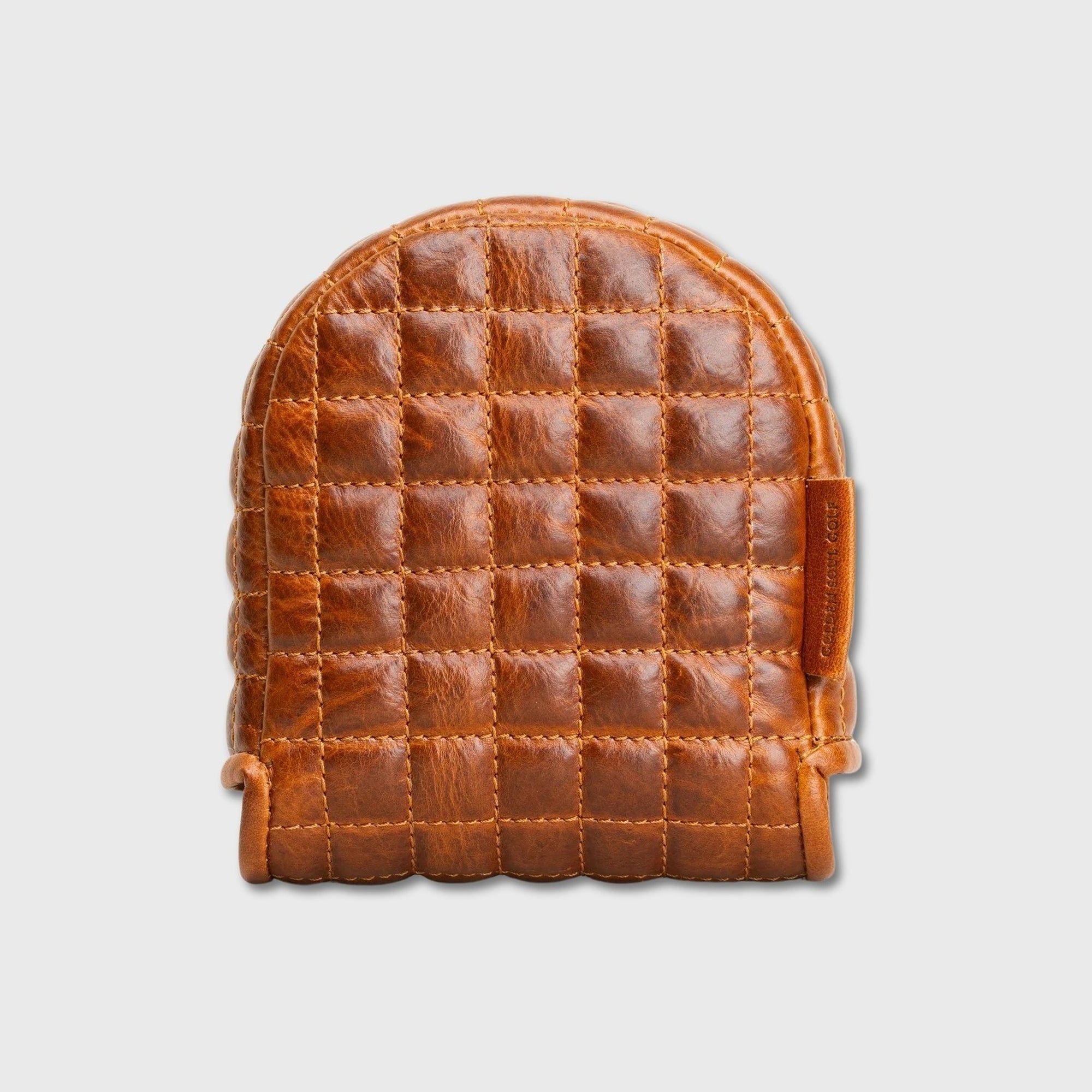 A small quilted leather DF3 putter cover in a warm cognac brown, featuring a stitched grid pattern and a side tab, shown against a light gray background.