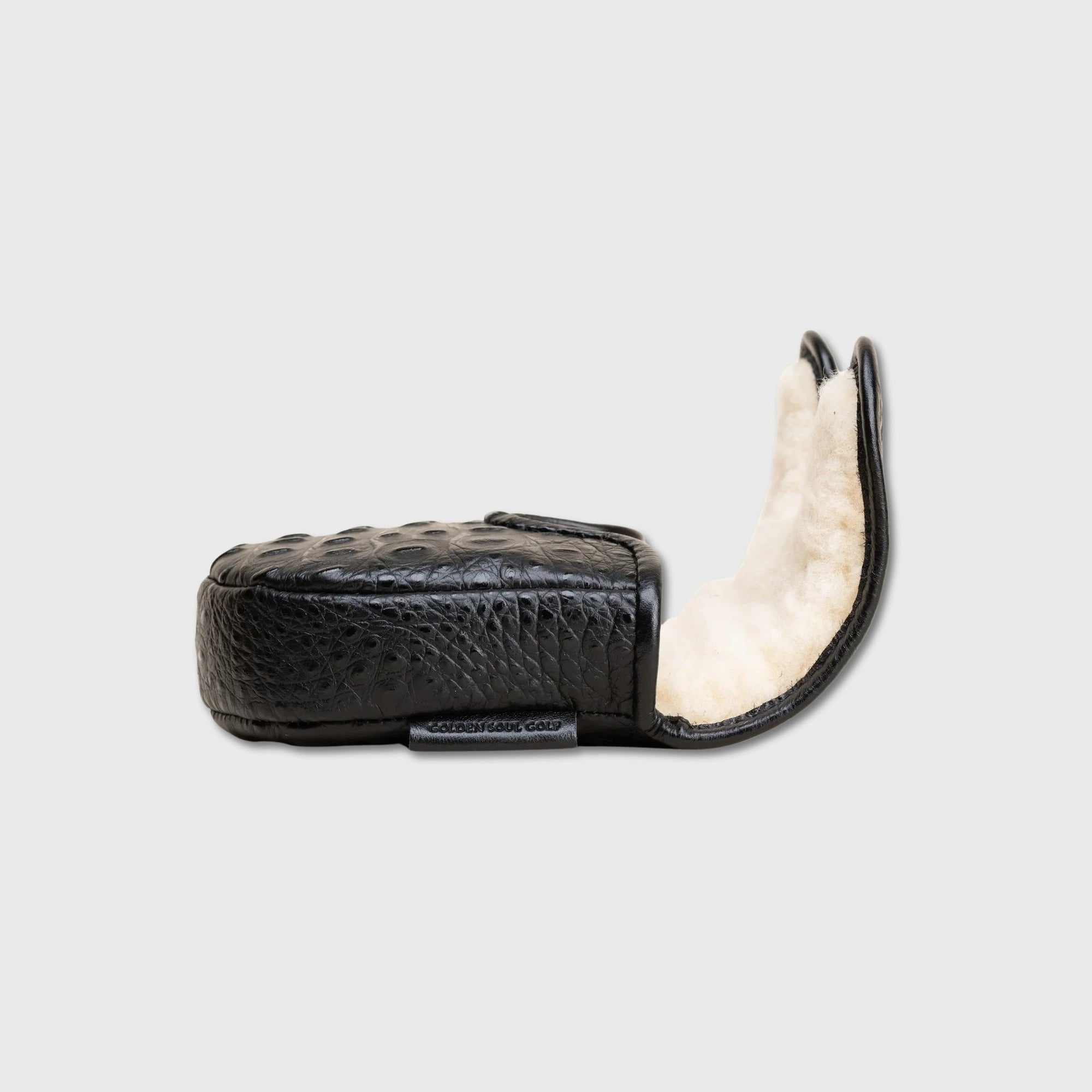 A black crocodile-embossed leather DF3 putter cover with a white sheepskin lining, shown open against a light gray background.