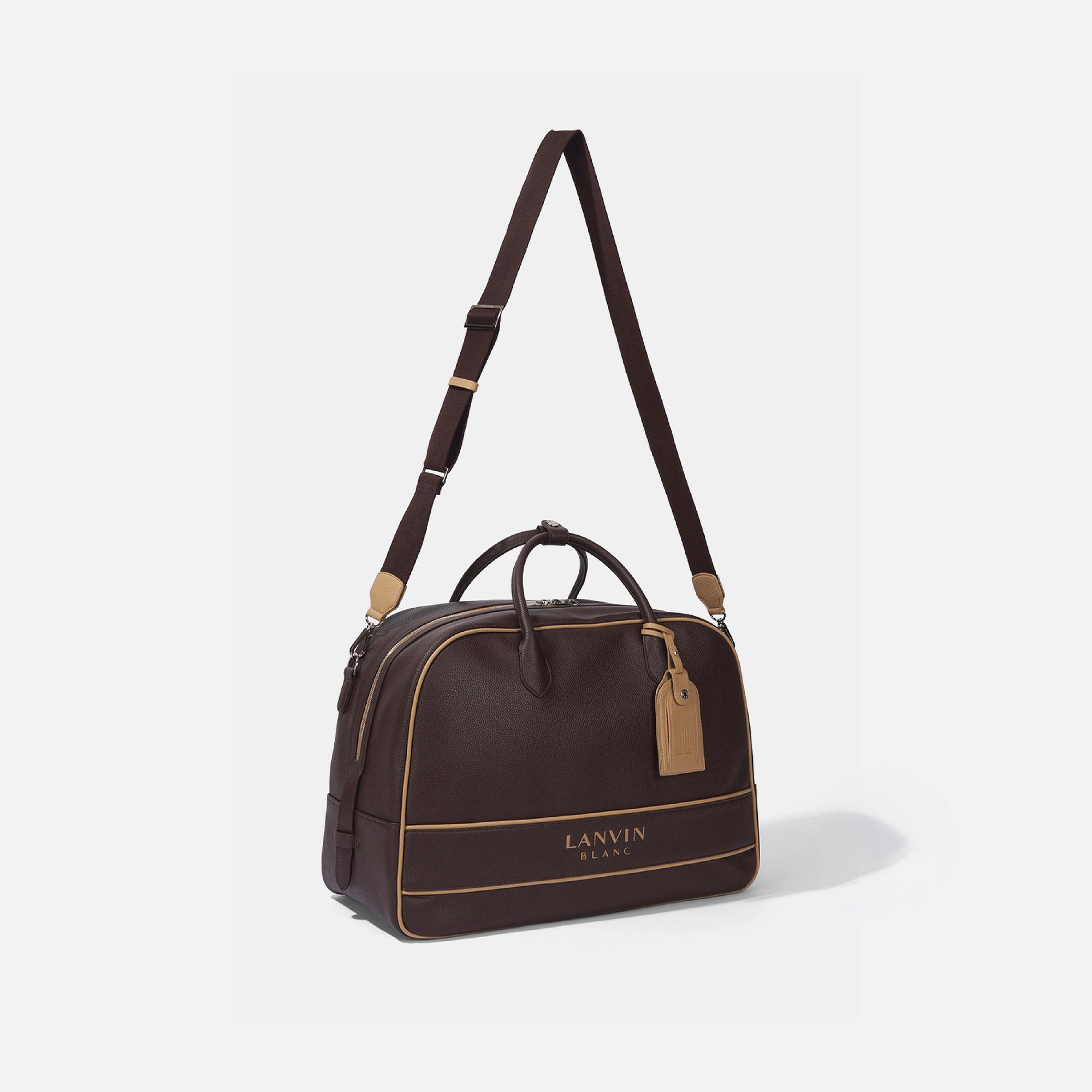 A dark brown leather duffel bag with tan accents, featuring a long shoulder strap, top handles, and the 'LANVIN BLANC' logo on the front, set against a light gray background.