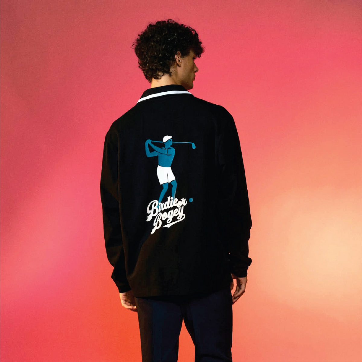 A man viewed from behind wearing a black bomber jacket with a large graphic on the back. The graphic features a golfer in blue and white with the text 'Birdie or Bogey'.