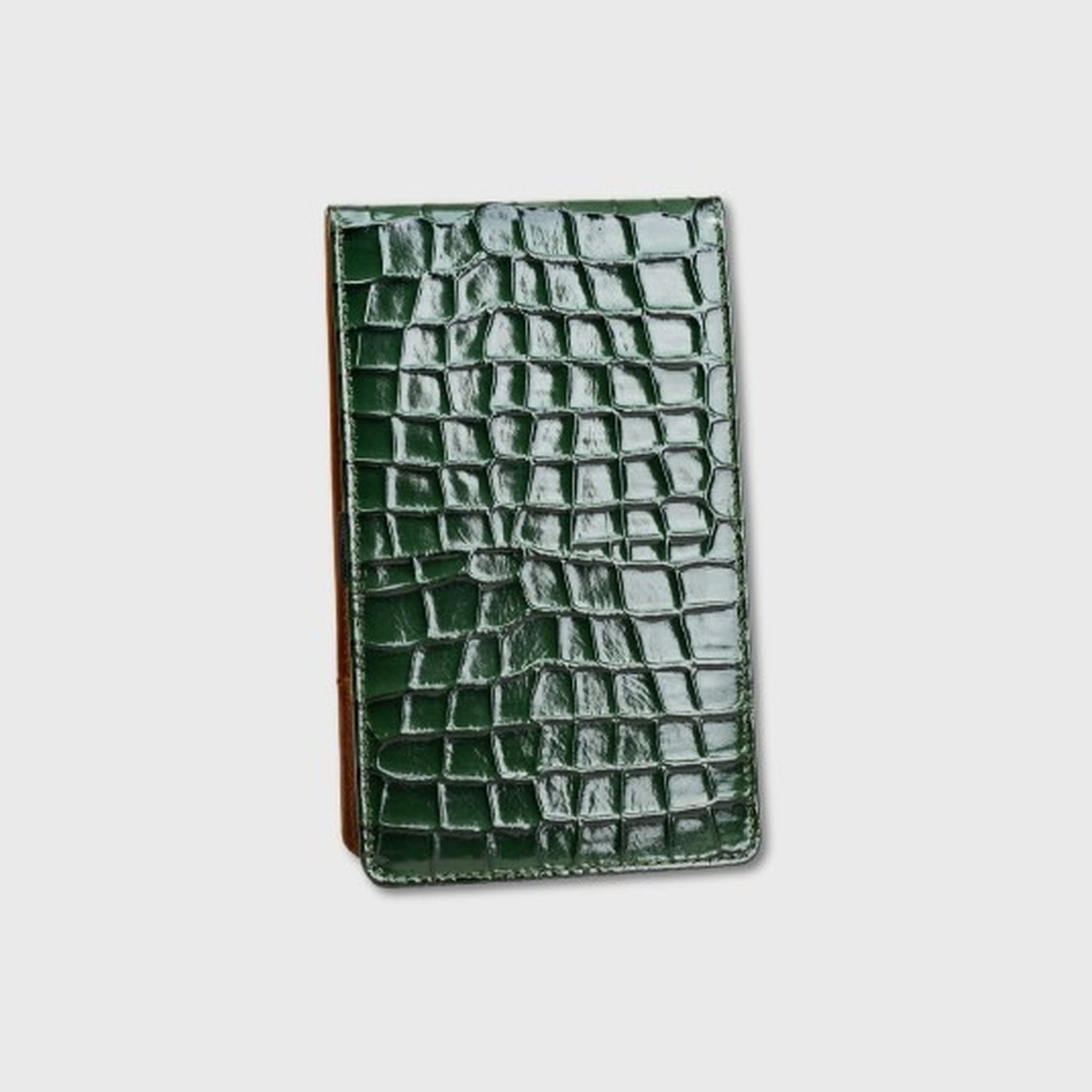 A dark green crocodile-embossed leather yardage book holder, shown closed on a light gray background.