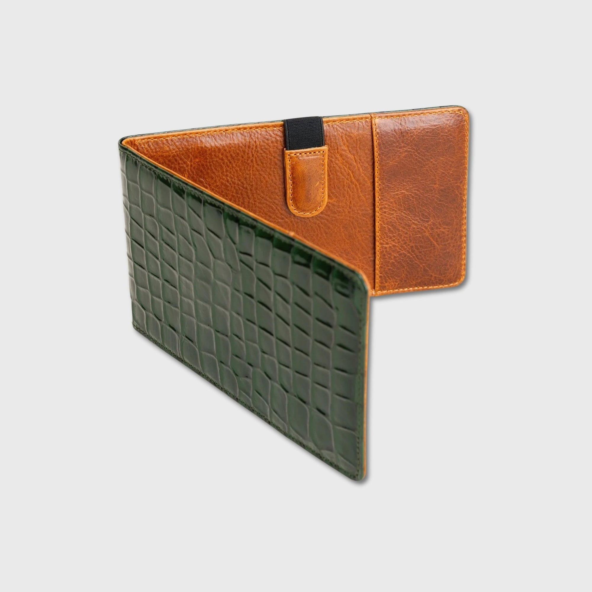 A two-tone leather  yardage book holder with a dark green crocodile-embossed front and a tan leather back, shown on a light gray background.