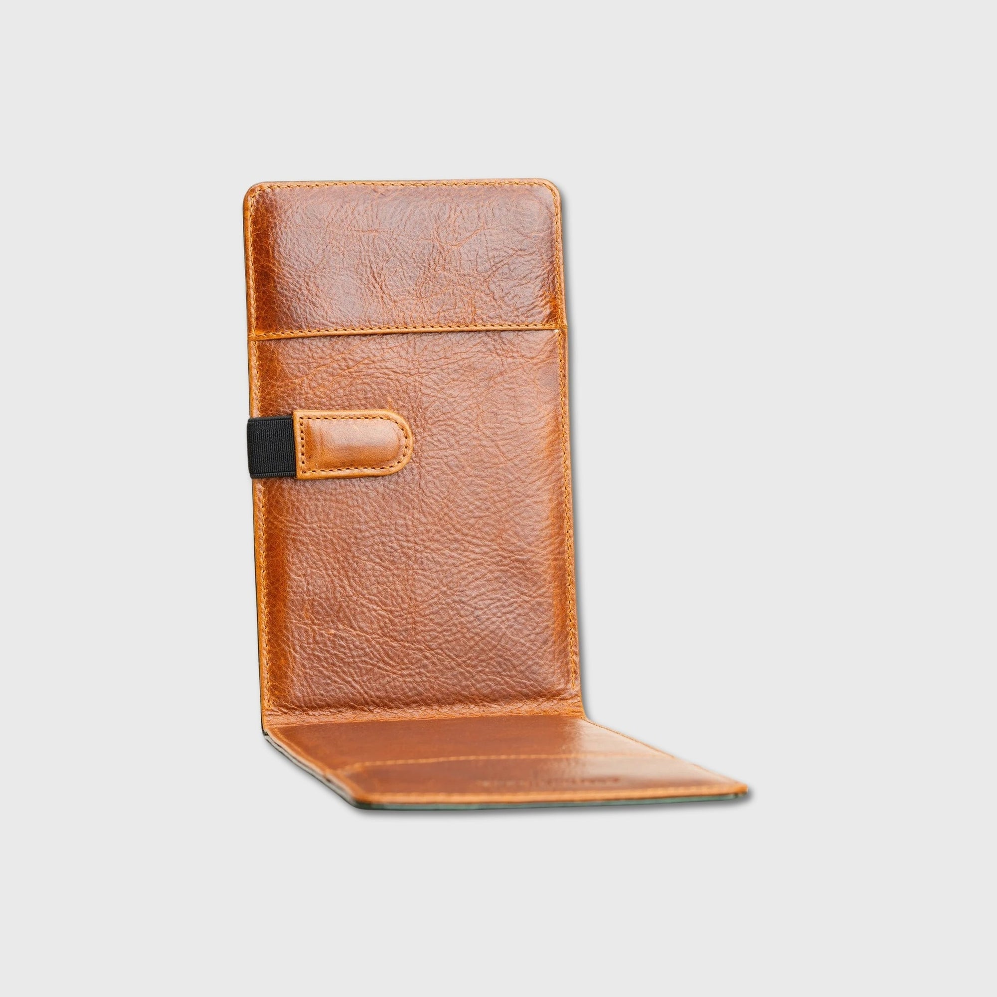 A brown textured leather yardage book holder shown open against a light gray background, featuring a vertical card slot and a small black accent tab on the side.