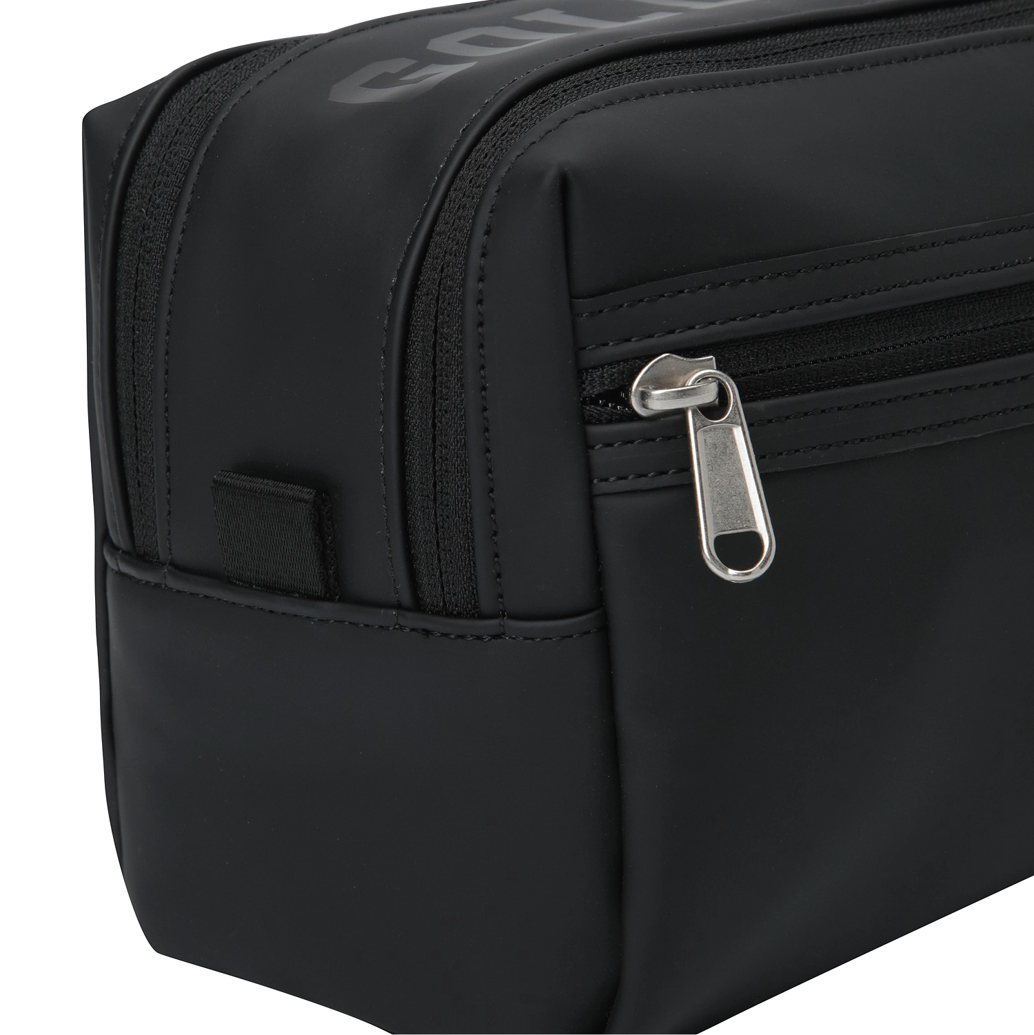 Close-up of a black nylon toiletry bag showing a zippered compartment with a silver metal pull tab and a small side hook-and-loop strap.