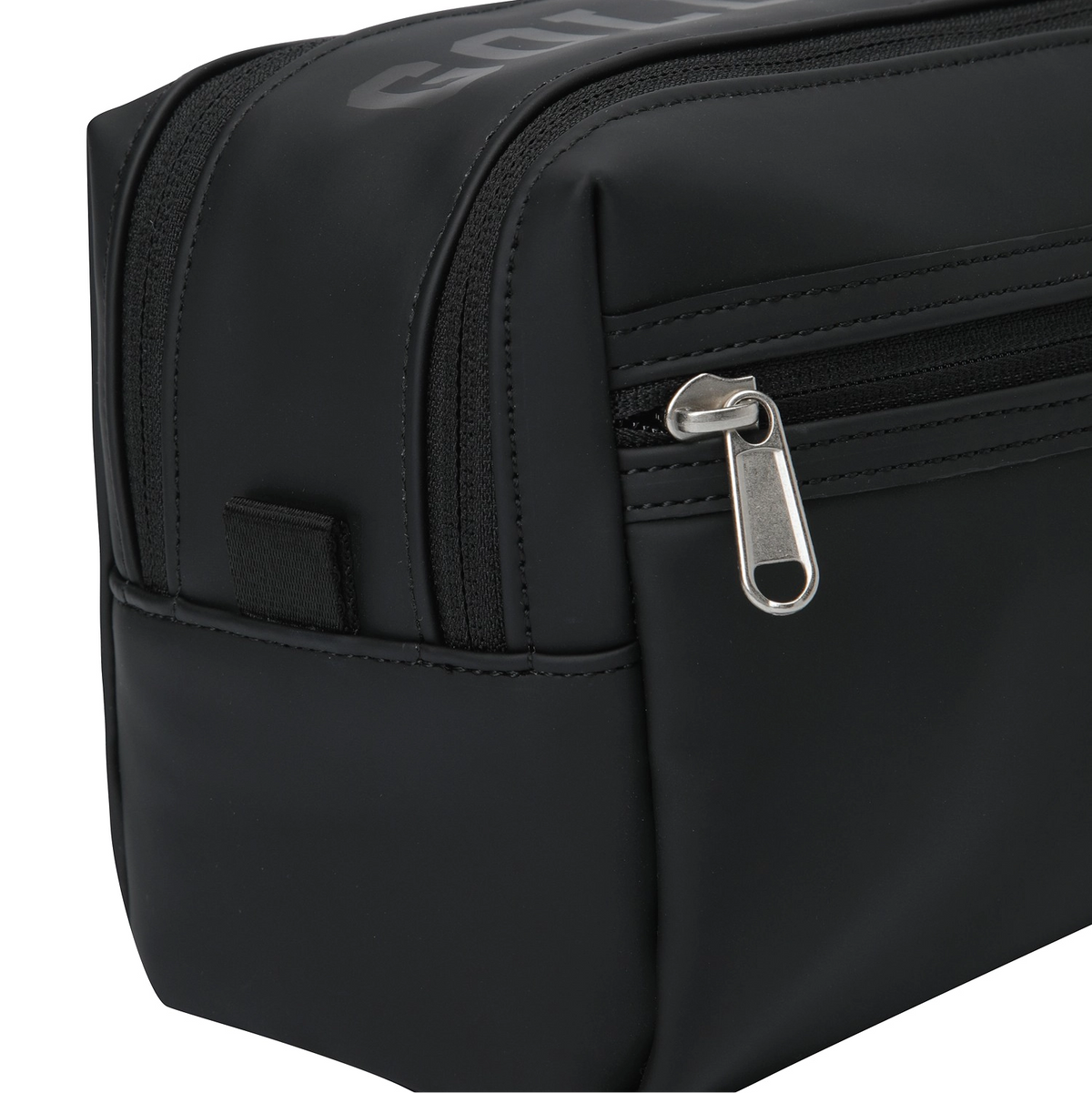 Close-up of a black nylon toiletry bag showing a zippered compartment with a silver metal pull tab and a small side hook-and-loop strap.