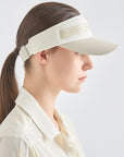 Woman wearing a beige visor against a light gray background