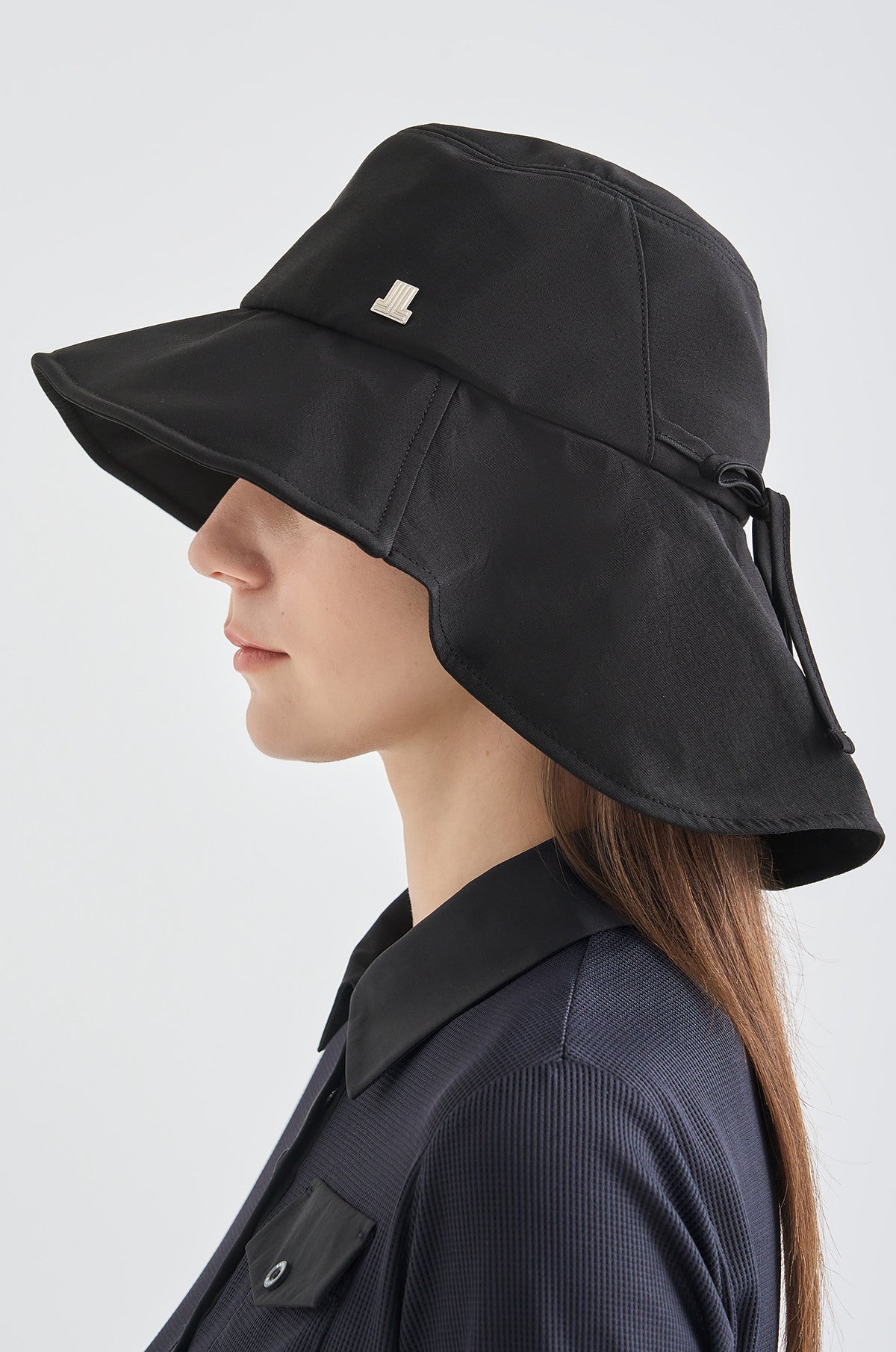 Person wearing a black wide-brimmed hat on a white background