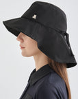 Person wearing a black wide-brimmed hat on a white background