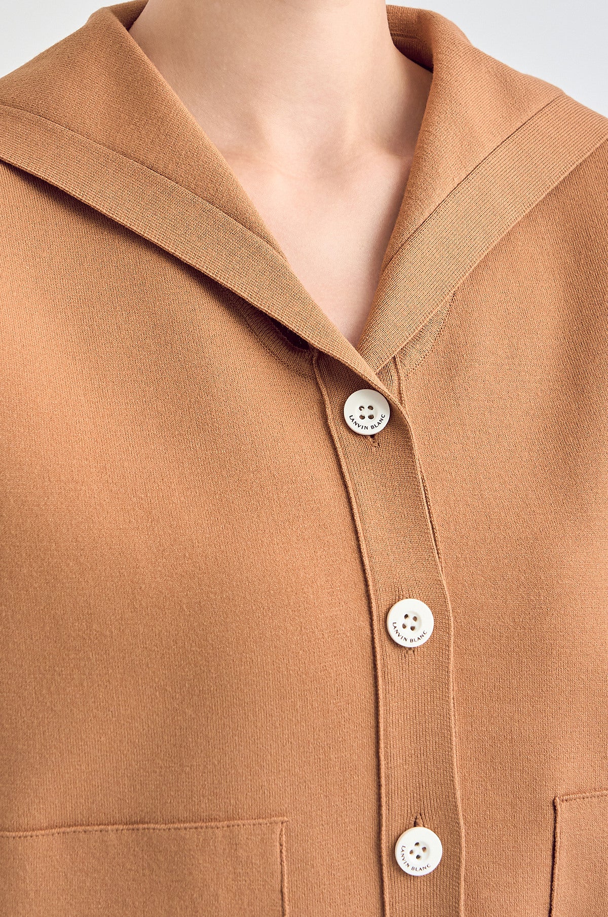 Close-up of a brown shirt with buttons on a neutral background
