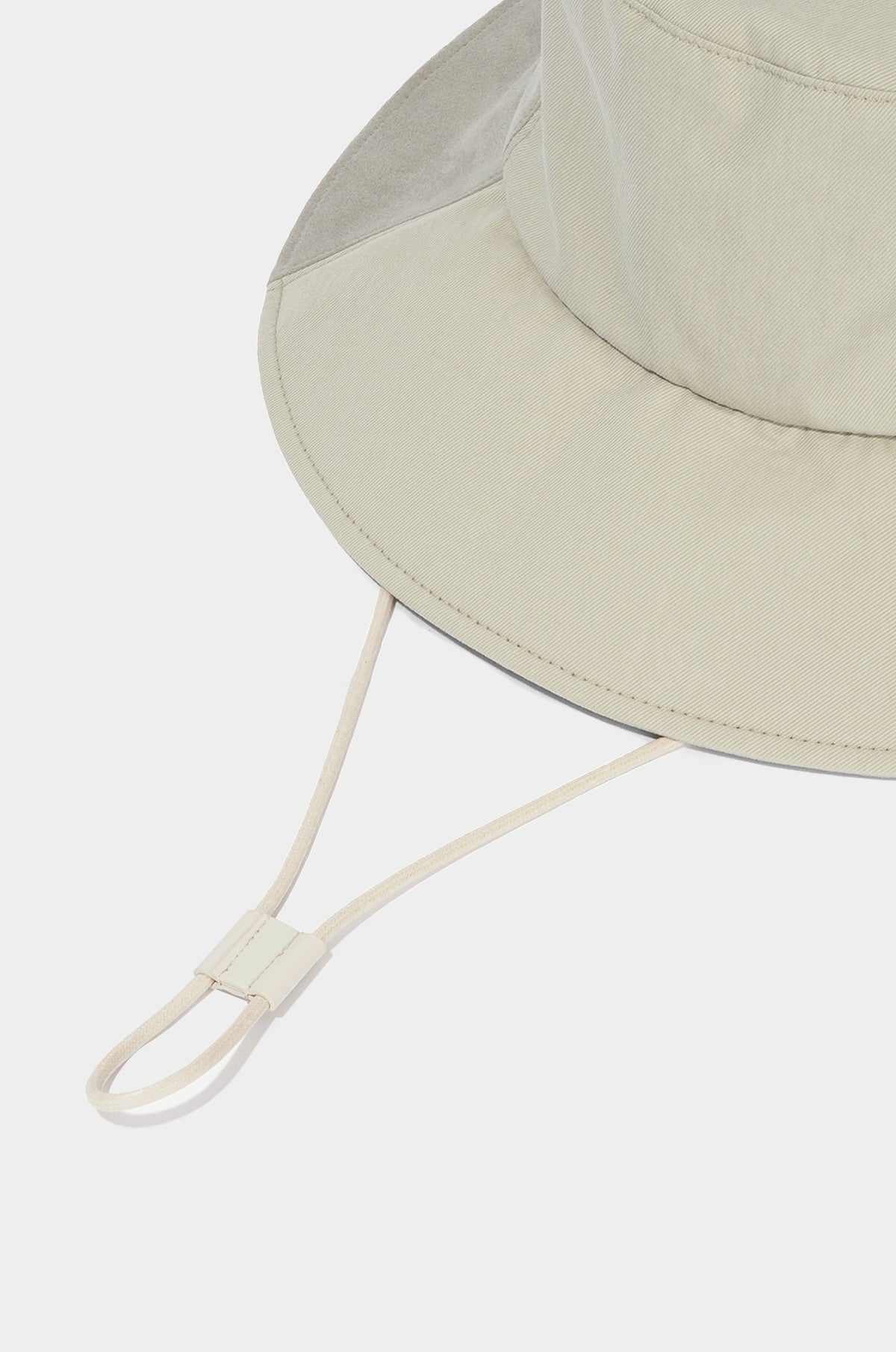 Beige bucket hat with a chin strap on a white background