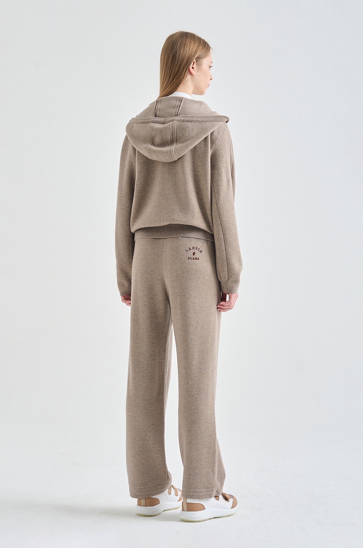 Woman wearing a beige hoodie on a white background