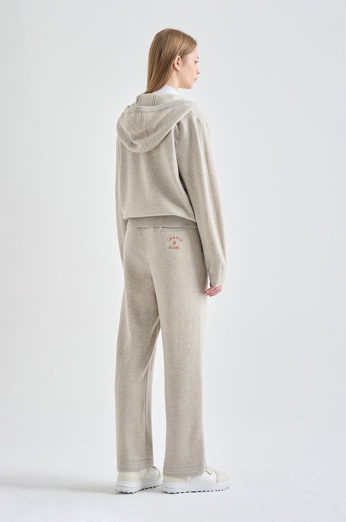Woman wearing a beige hoodie on a white background