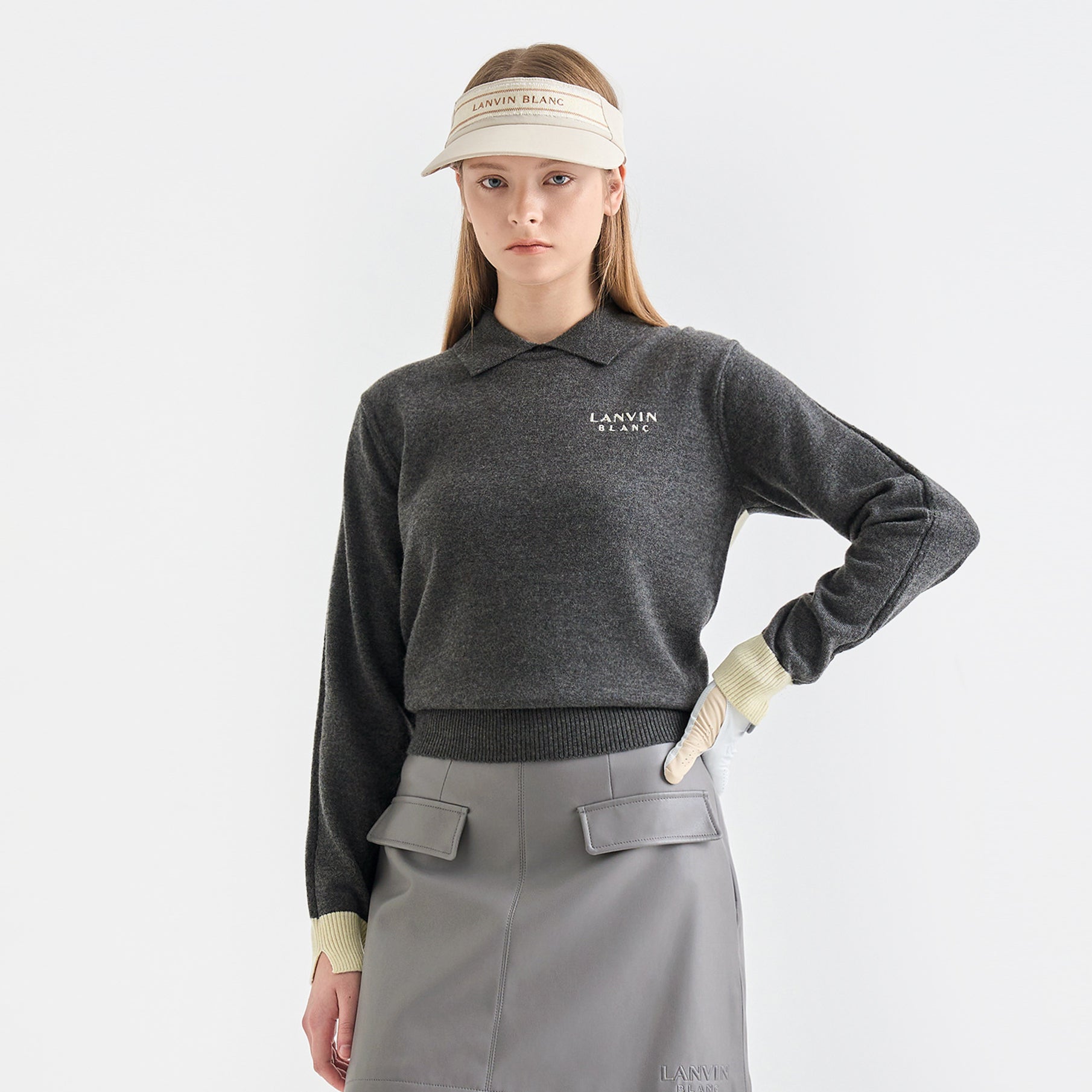 Person wearing a gray Lanvin outfit with a visor on a white background