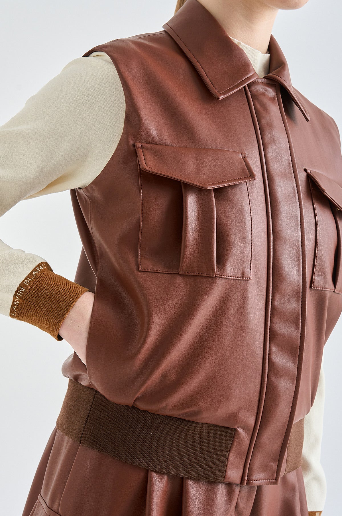 Brown leather vest worn by a person on a white background