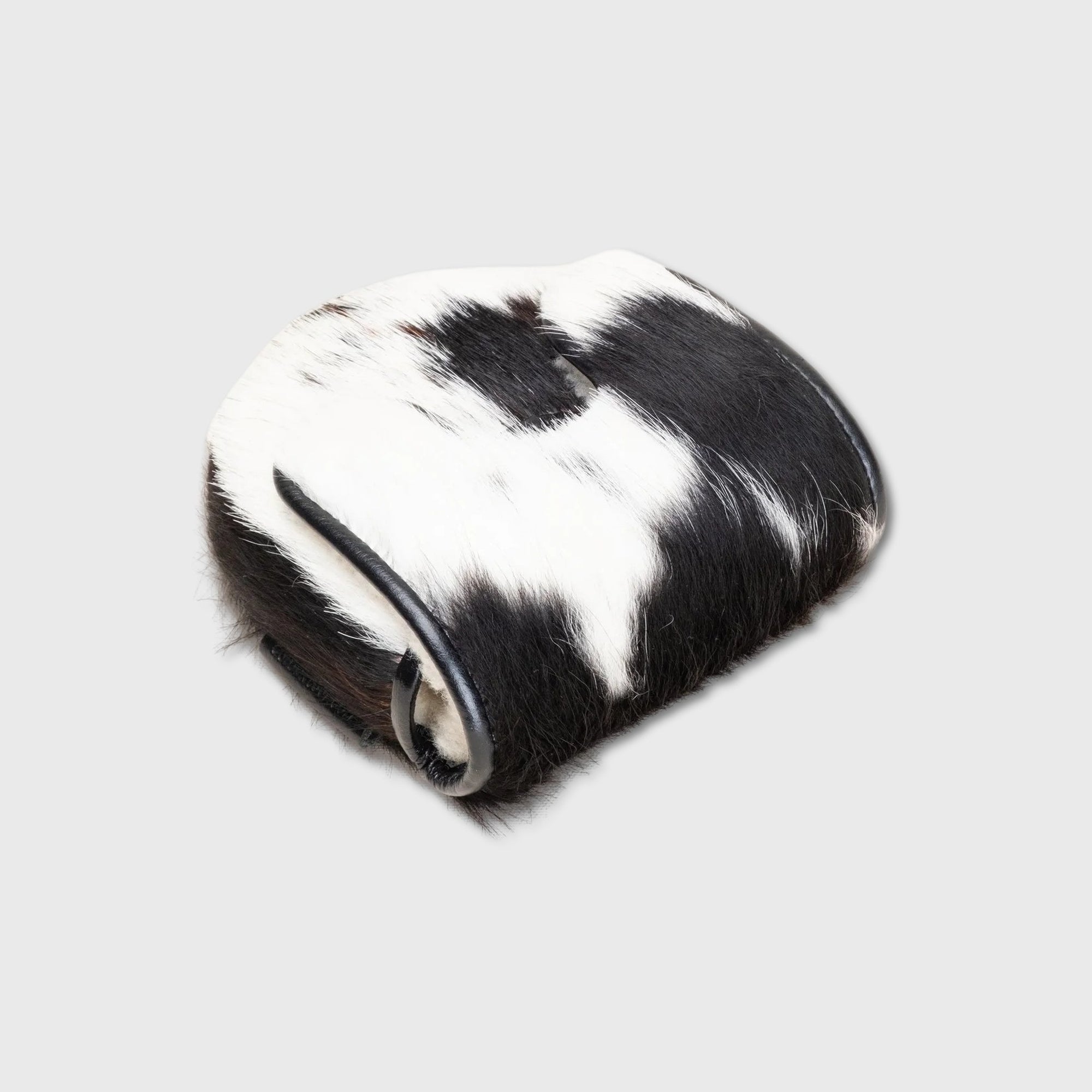 A rolled-up black and white cowhide Center DF3 Putter Cover with a smooth black leather strap, shown on a light gray background.