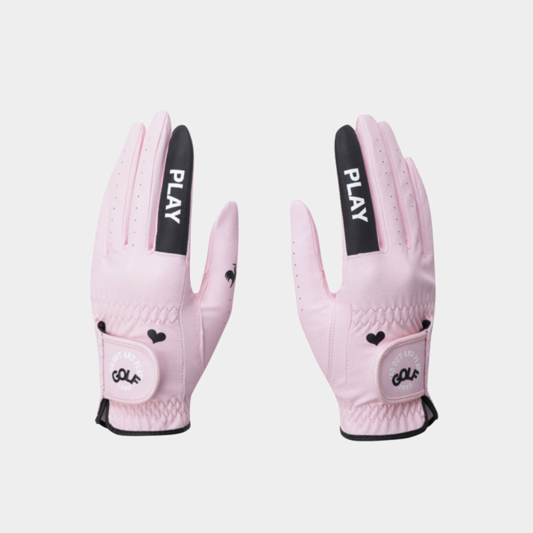 A pair of light pink golf gloves with black accents, featuring the brand name 'PLAY' on the back of the hands and 'GOLF' on the wrist strap, displayed against a light gray background.