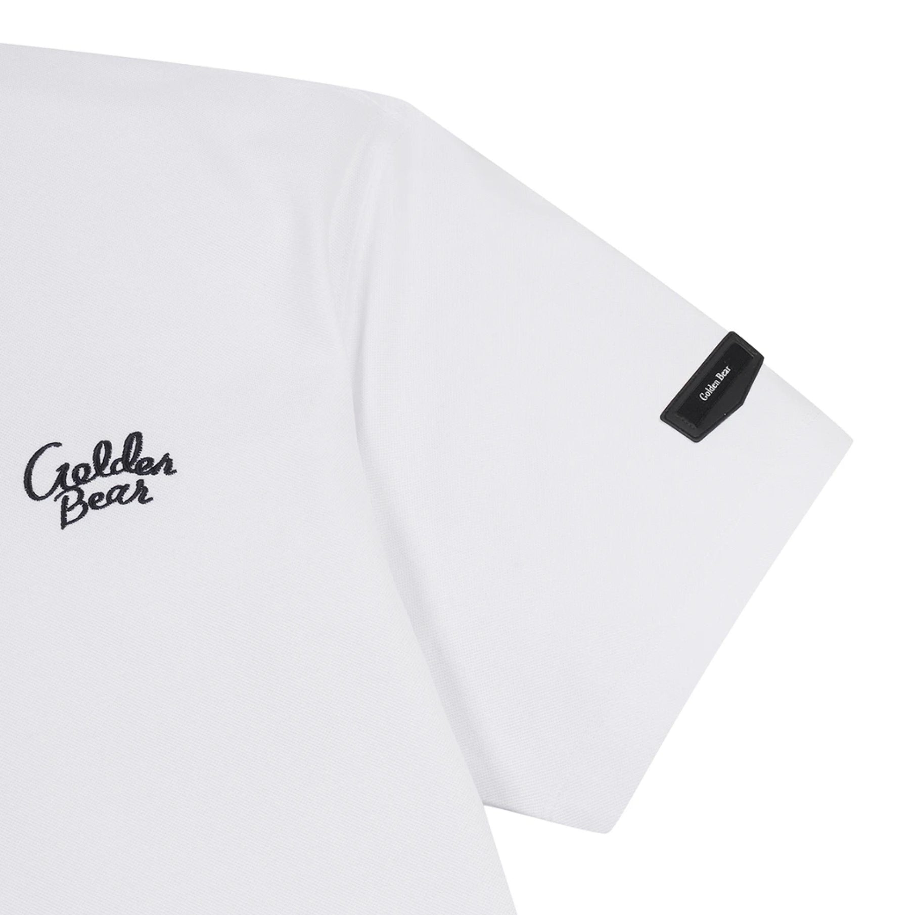 Close-up of a white short-sleeve T-shirt showing the left chest with a black 'Golden Bear' script logo and a black brand tag on the sleeve, on a white background.