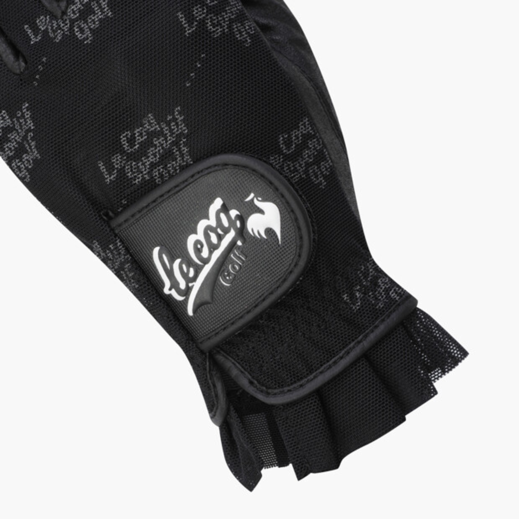 Close-up of a black Le coq grip glove with a white Le coq brand patch on the wrist strap, set against a plain white background.
