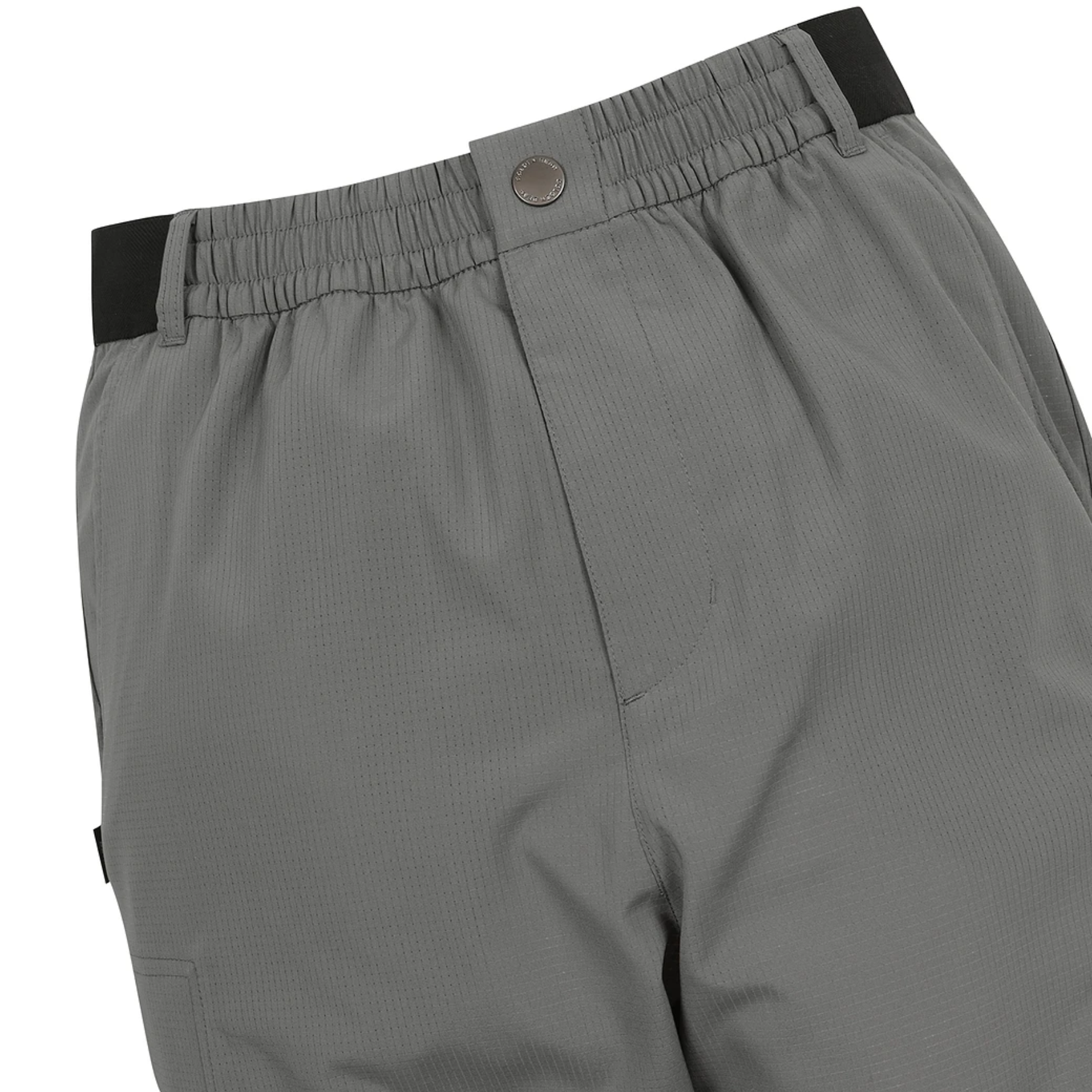 Close-up of gray athletic pants showing the elastic waistband with a black side tab, a metal snap button, and the side pocket.
