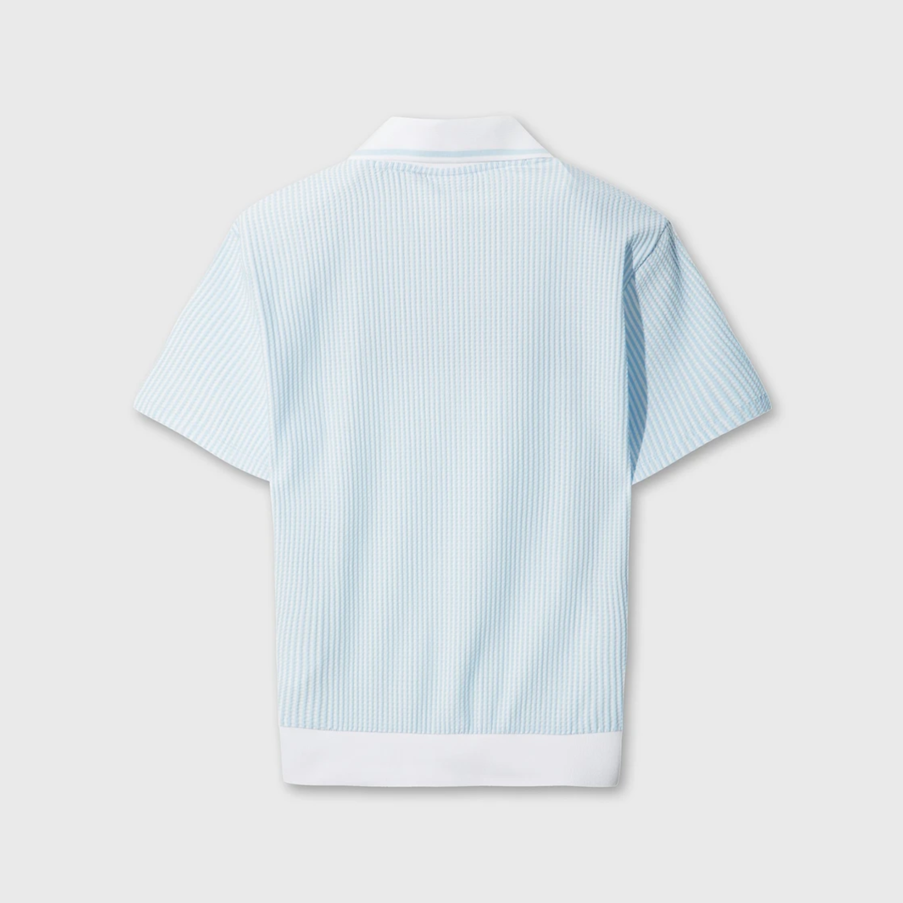 Back view of women's light blue seersucker golf polo with white collar and ribbed hem.