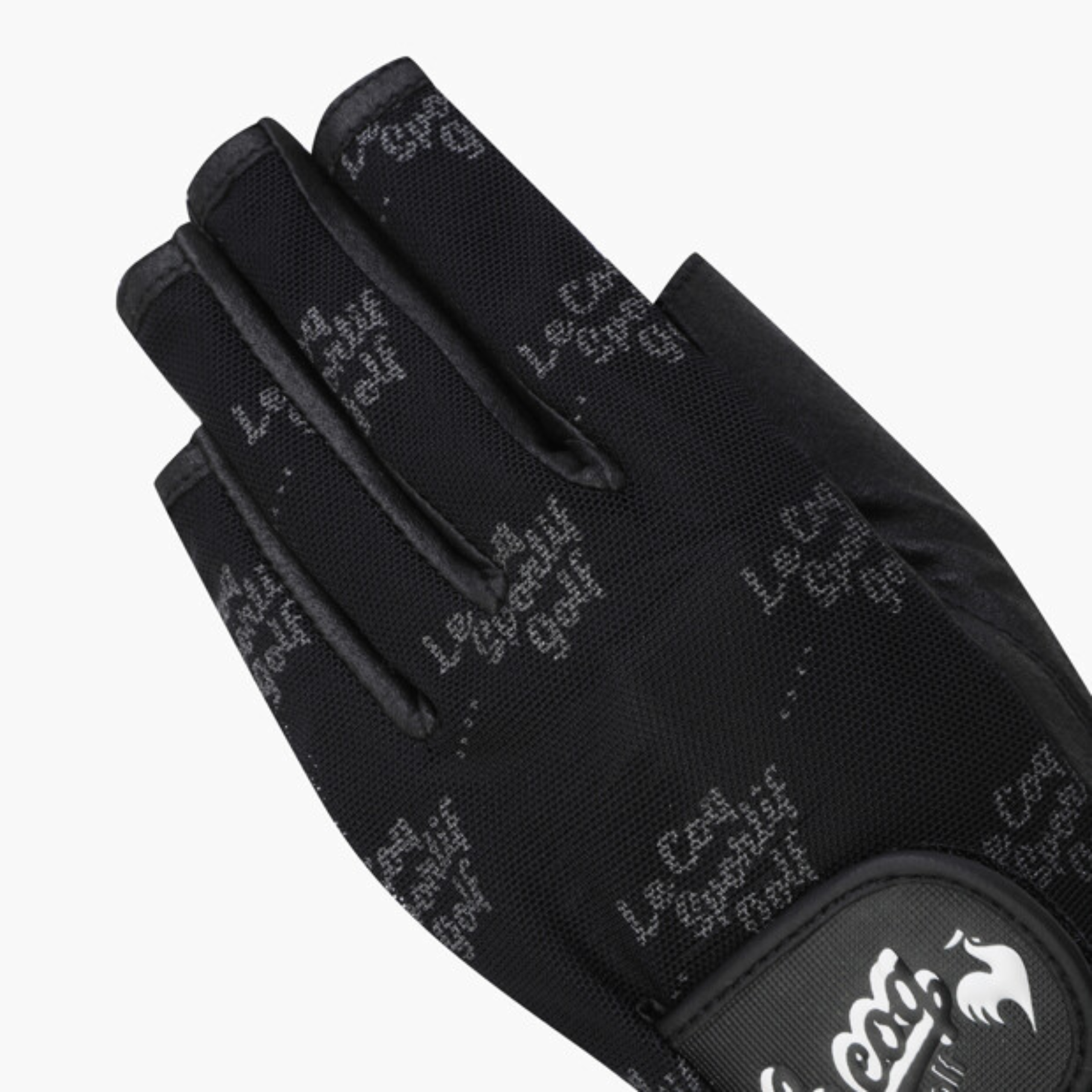 A close-up of a black fingerless golf glove with a subtle gray repeating script pattern and a black wrist patch featuring a white logo.