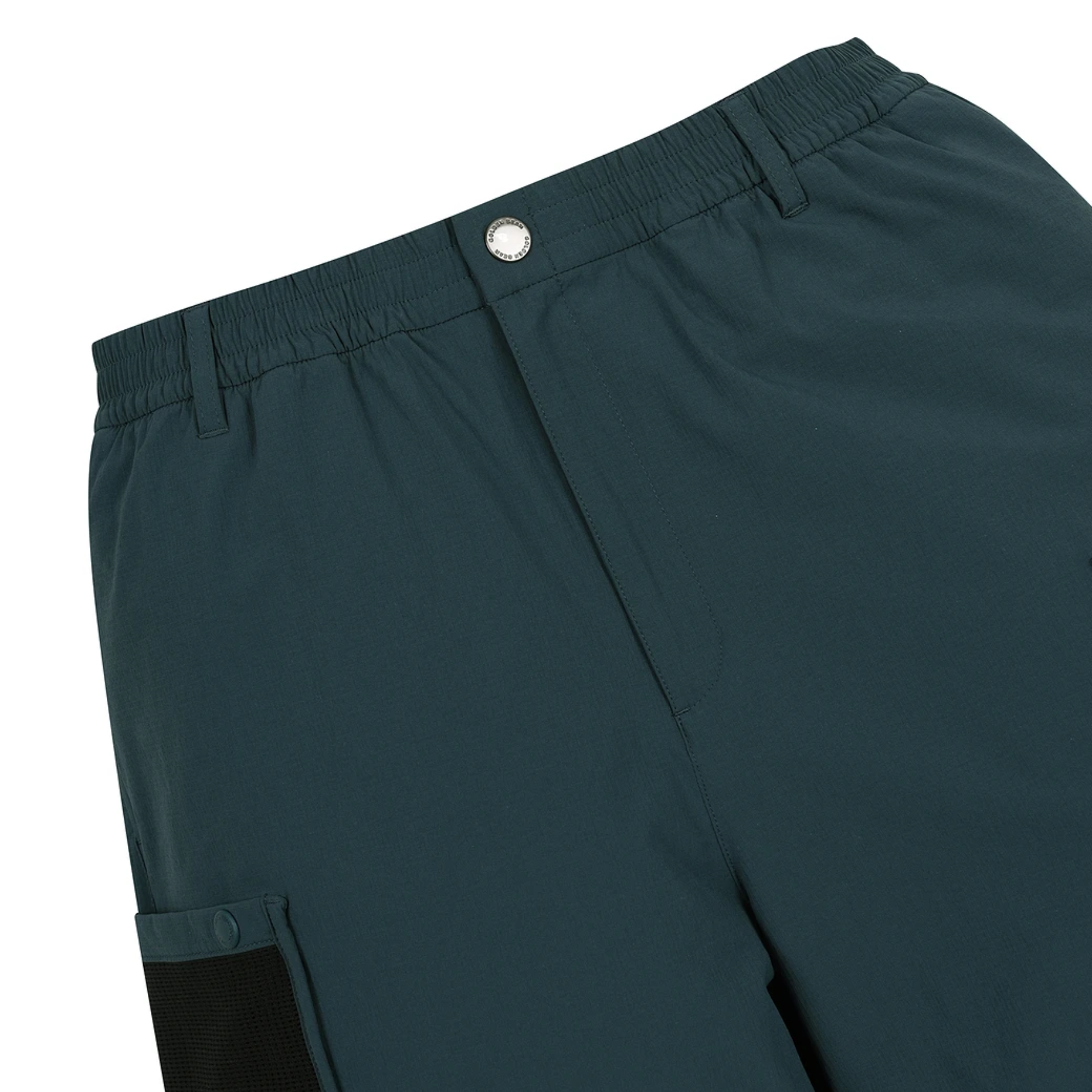 Close-up of the waistband and front of dark teal athletic shorts, showing an elastic waist, a silver snap button, and a side pocket with a black mesh accent panel.