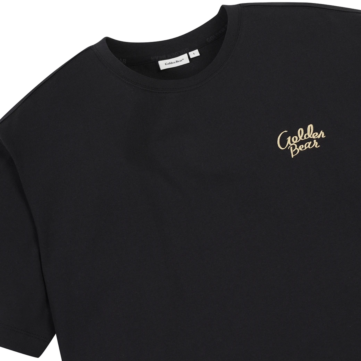 A close-up of a black short-sleeve crewneck t-shirt featuring the brand name 'Golden Bear' embroidered in gold cursive script on the left chest.