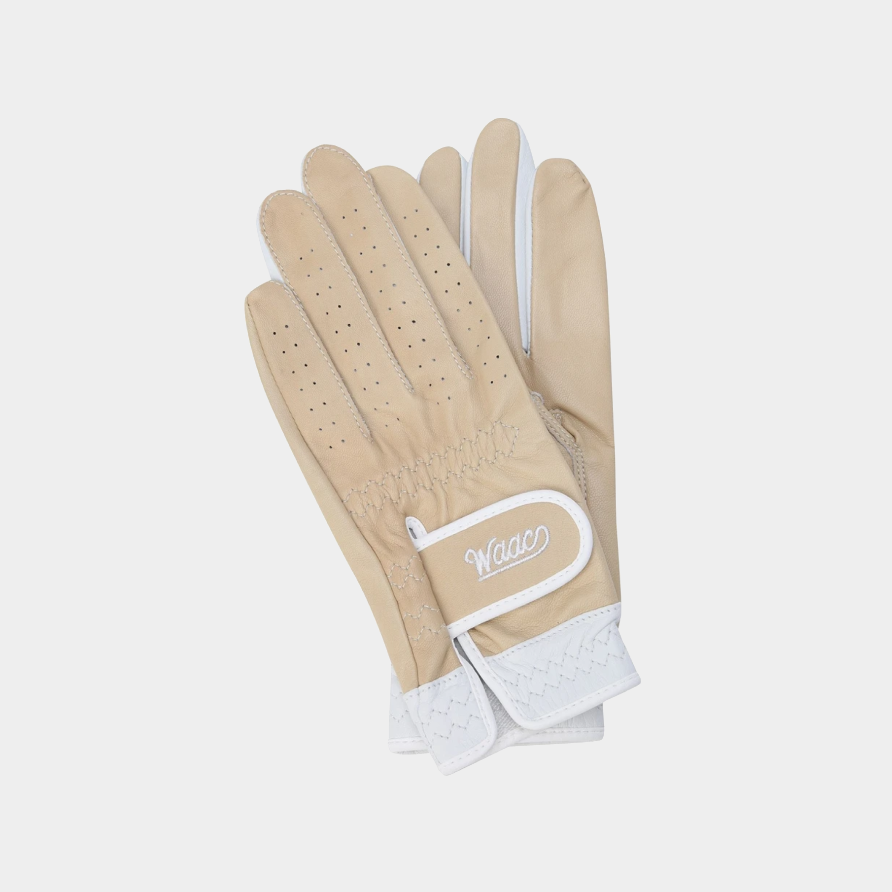 A pair of beige leather golf gloves with white trim and a white logo patch on the back, displayed against a light gray background.