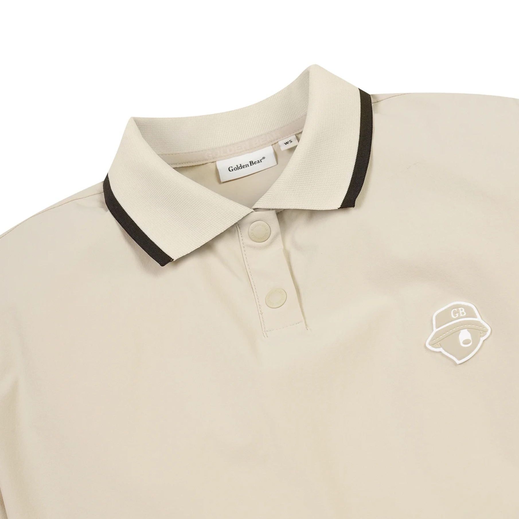 A close-up of a light beige polo shirt by Golden Bear, featuring a black and beige striped collar, a two-button placket, and a white embroidered chest logo.