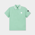 A mint green short-sleeve polo shirt with a white collar, featuring a small white logo on the left chest and a black brand patch on the right sleeve, displayed on a light gray background.