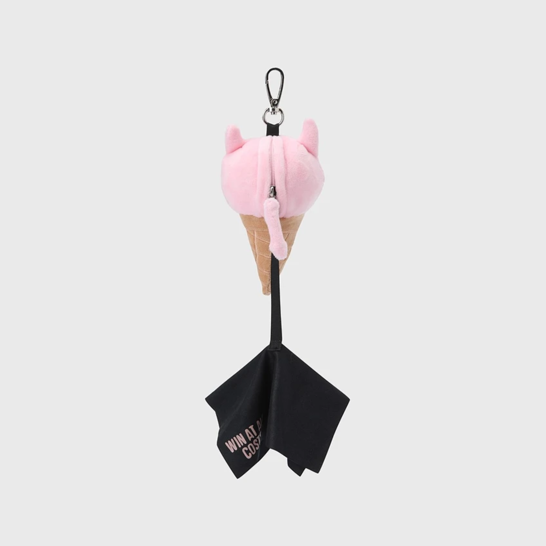 A plush ice cream cone keychain or bag charm with a pink cat-shaped plush on a tan cone, attached to a black strap with a black fabric tag that reads 'WIN IT AT ALL COSTS!' text, shown on a light gray background.