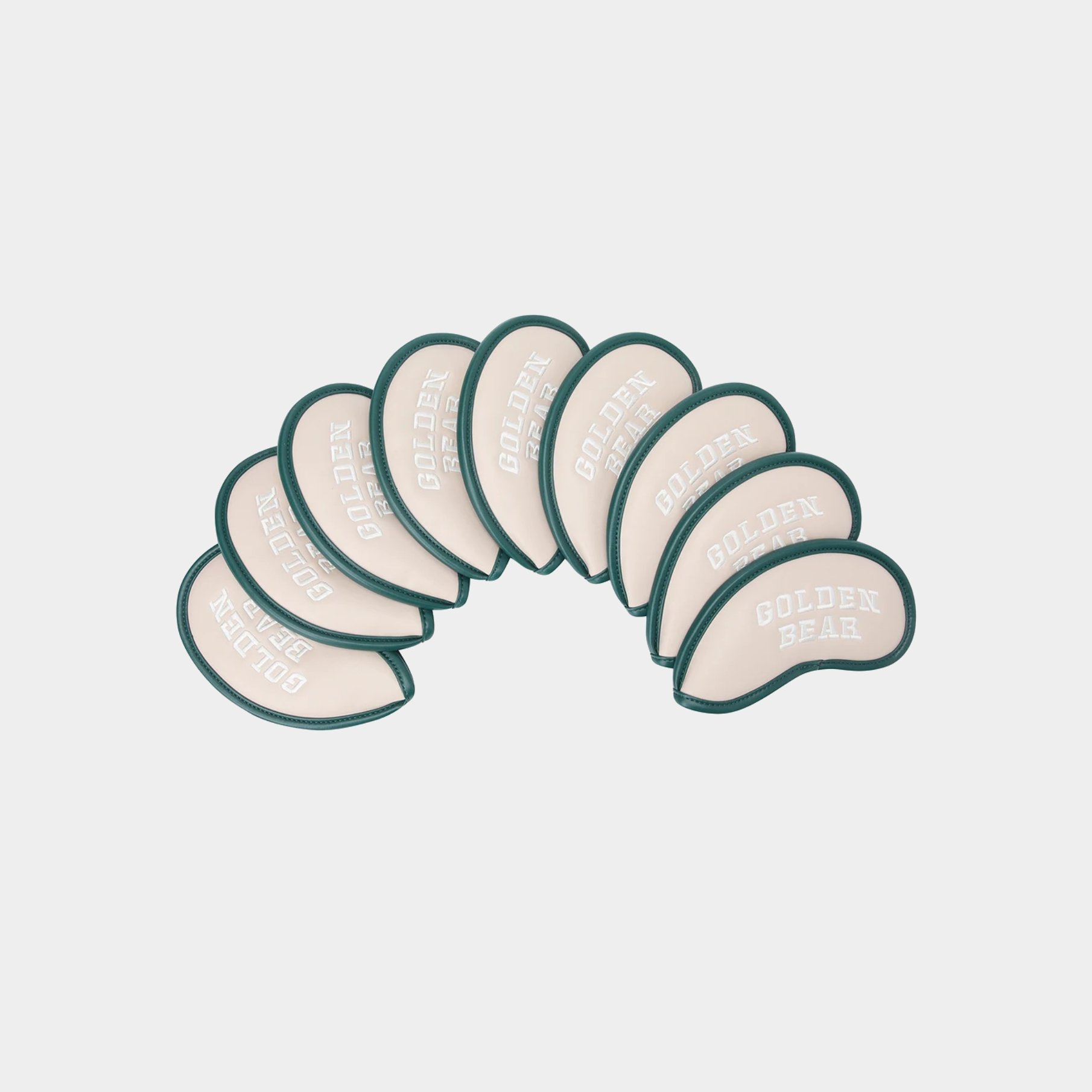 A set of nine golf tees arranged in an arc, featuring a cream-colored body with a dark green border and the words 'GOLDEN BEAR' printed on them, set against a light gray background.