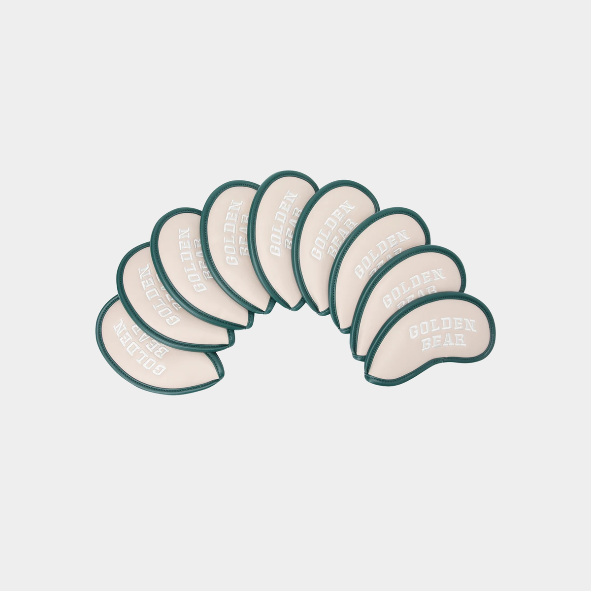 A set of nine golf tees arranged in an arc, featuring a cream-colored body with a dark green border and the words 'GOLDEN BEAR' printed on them, set against a light gray background.