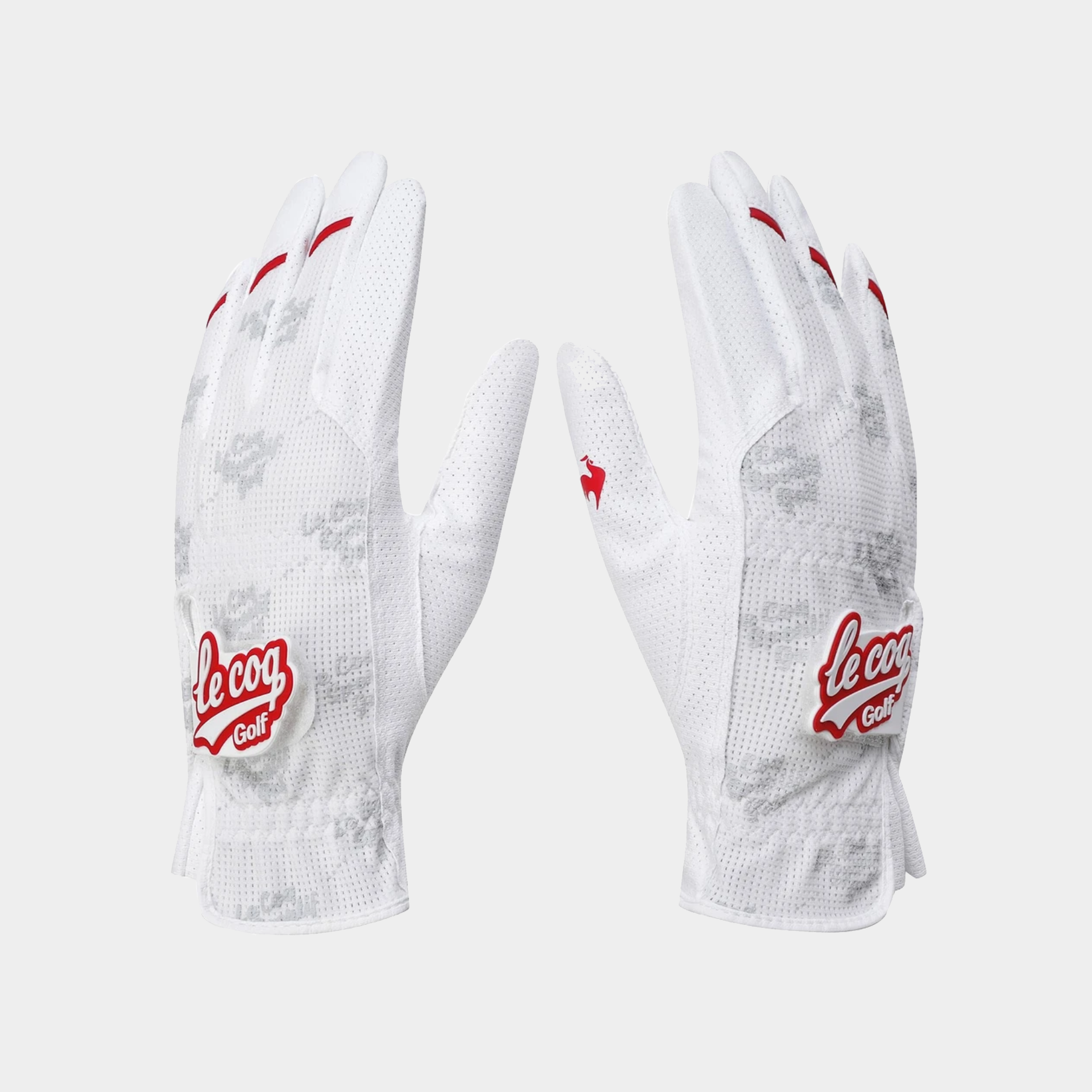 A pair of white Le Coq Golf golf gloves with red accents and a subtle gray camo pattern, displayed on a light gray background.