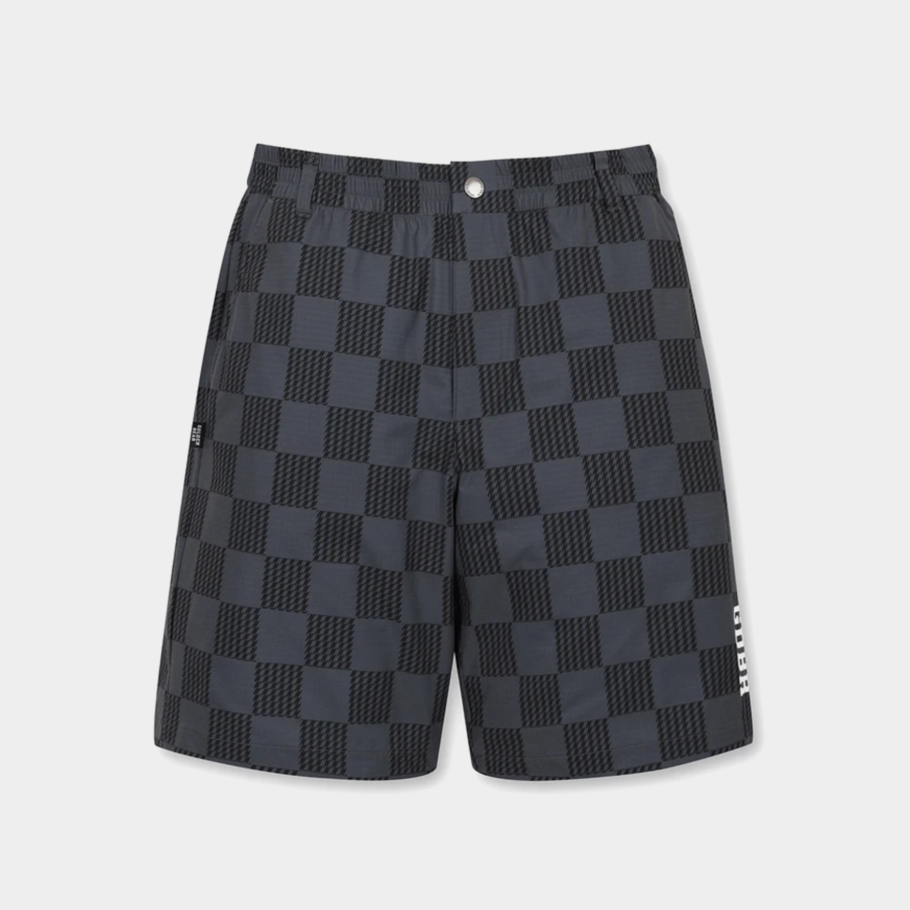 A pair of dark gray and black checkerboard patterned shorts with a white vertical logo on the lower left leg, displayed against a light gray background.