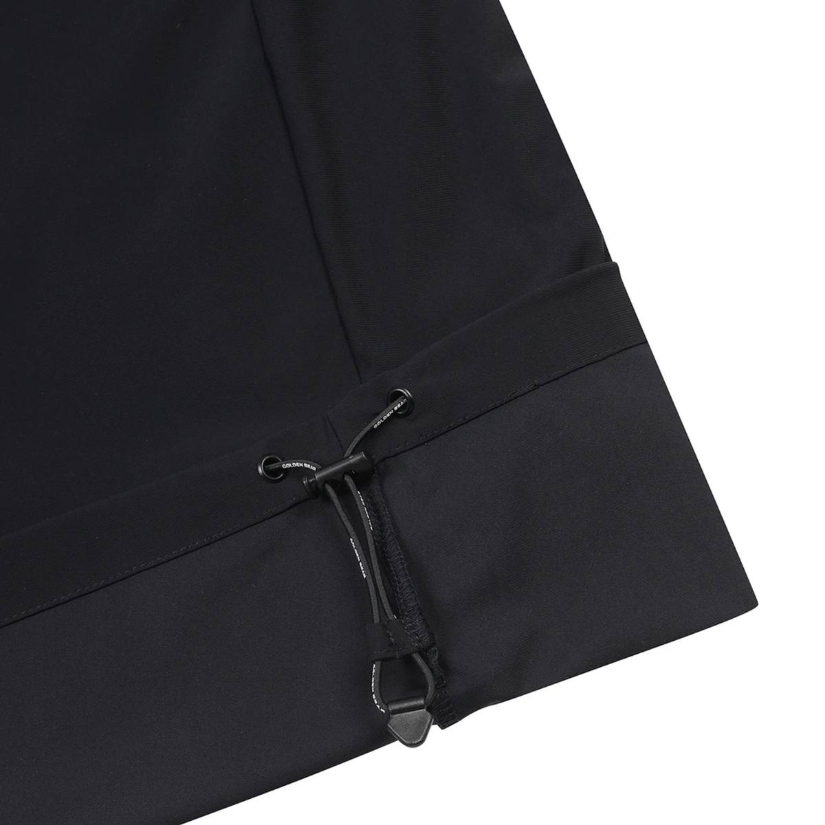 Close-up of a black garment sleeve or cuff with a drawstring toggle and elastic band, shown on a white background.