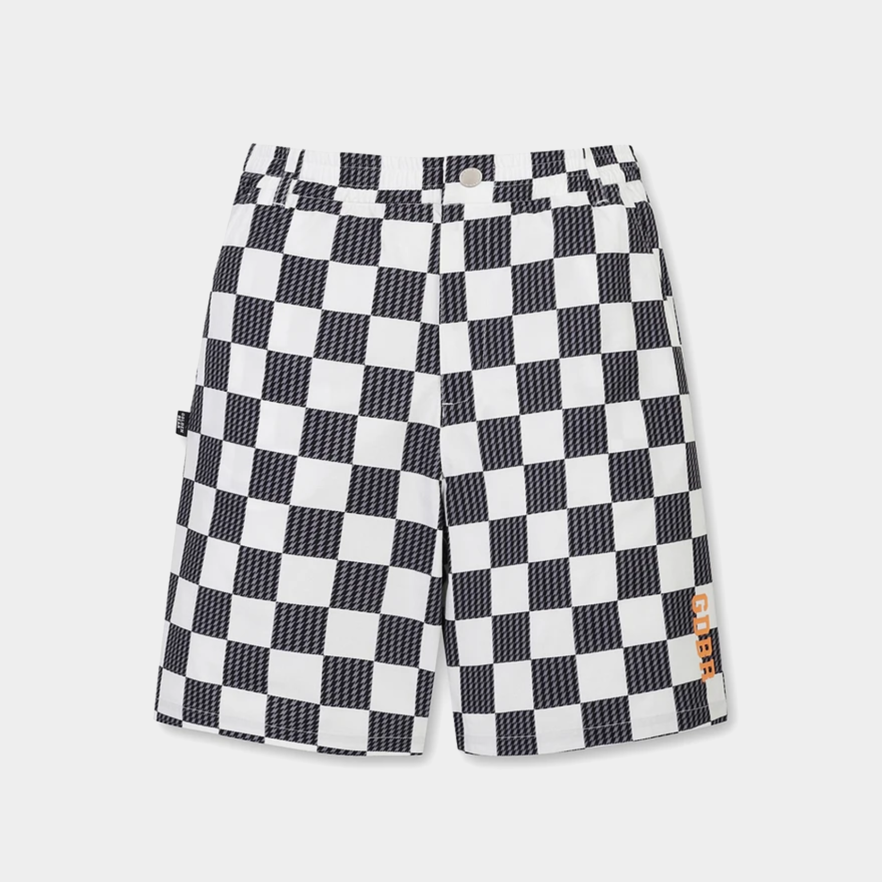 Black and white checkerboard shorts with a textured pattern, featuring a button closure and a small orange brand patch on the lower left hem, displayed against a light gray background.
