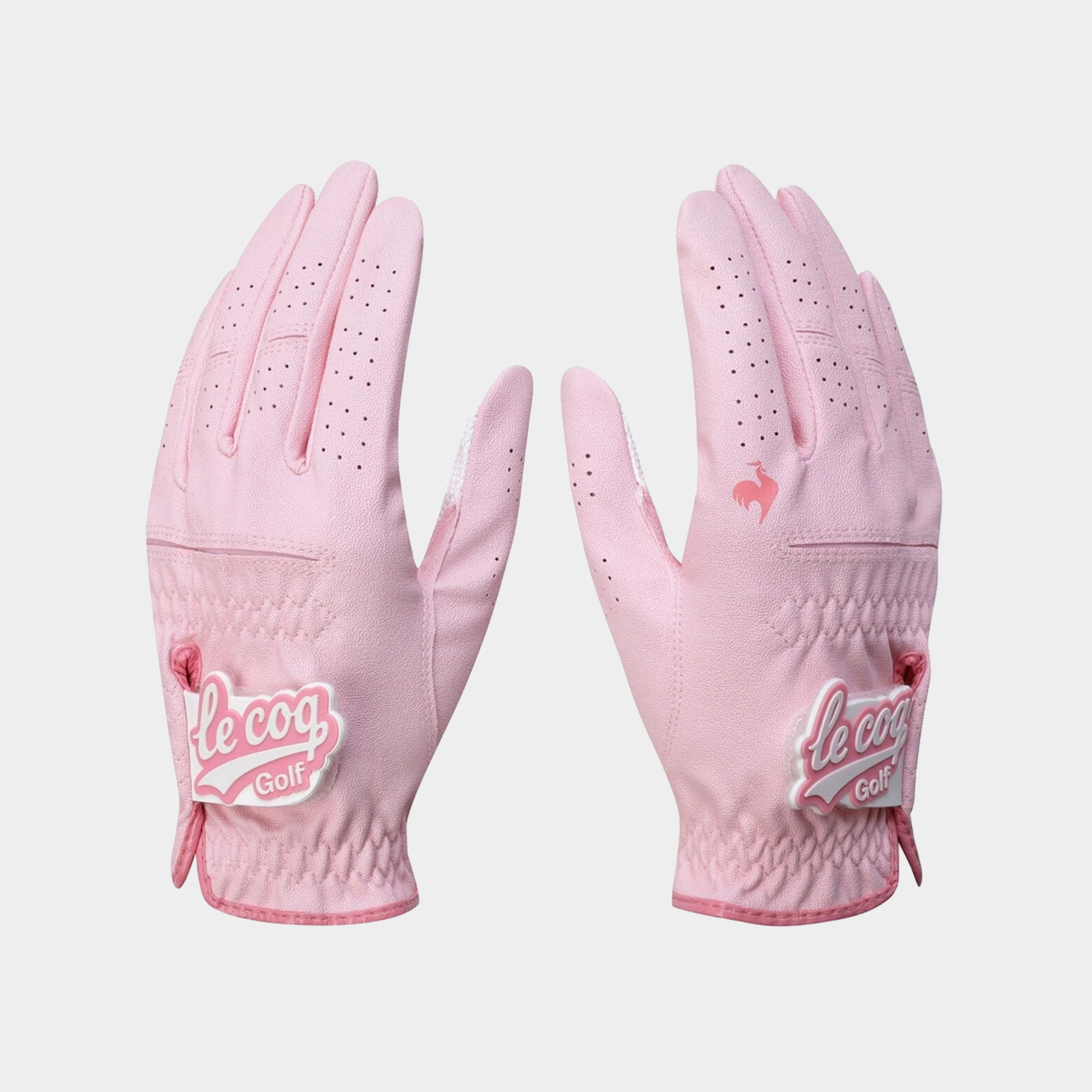 A pair of light pink golf gloves shown flat against a light gray background, with the Le Coq Golf brand logo visible on the wrist area.
