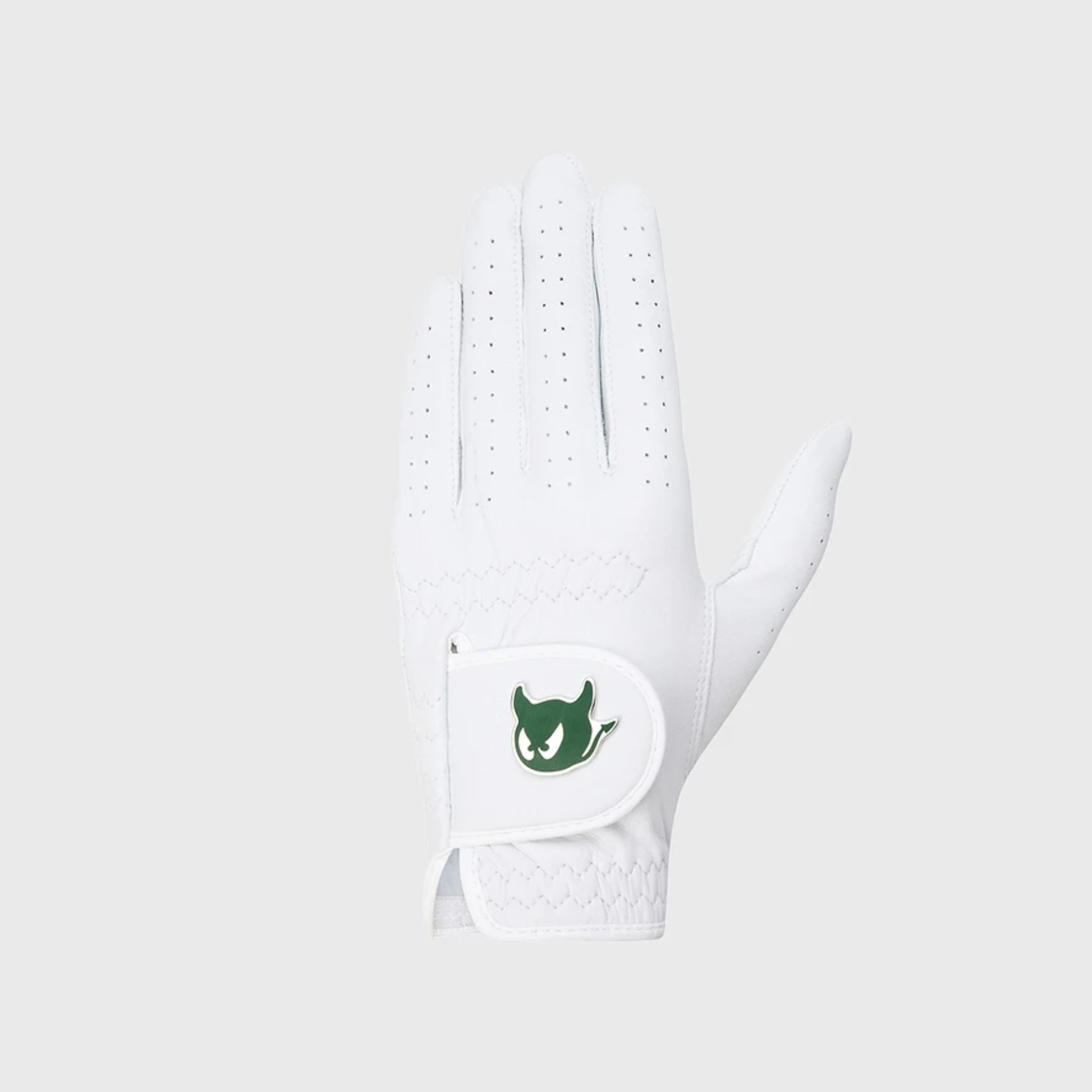A white golf glove with a green devil logo patch on the wrist strap, shown against a light gray background.