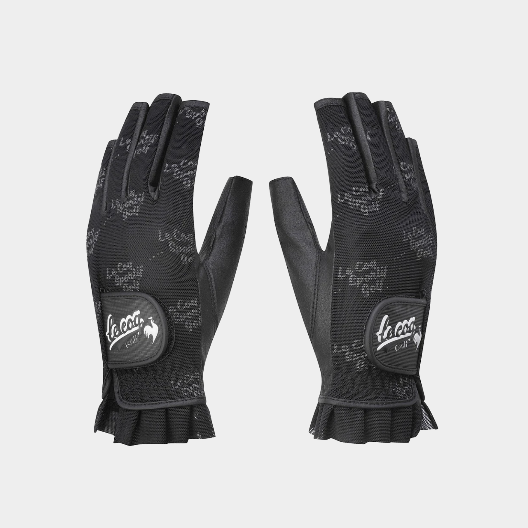A pair of black Le Coq Golf fingerless gloves with a textured patterned back and a black leather wrist patch featuring the white Le Coq logo.