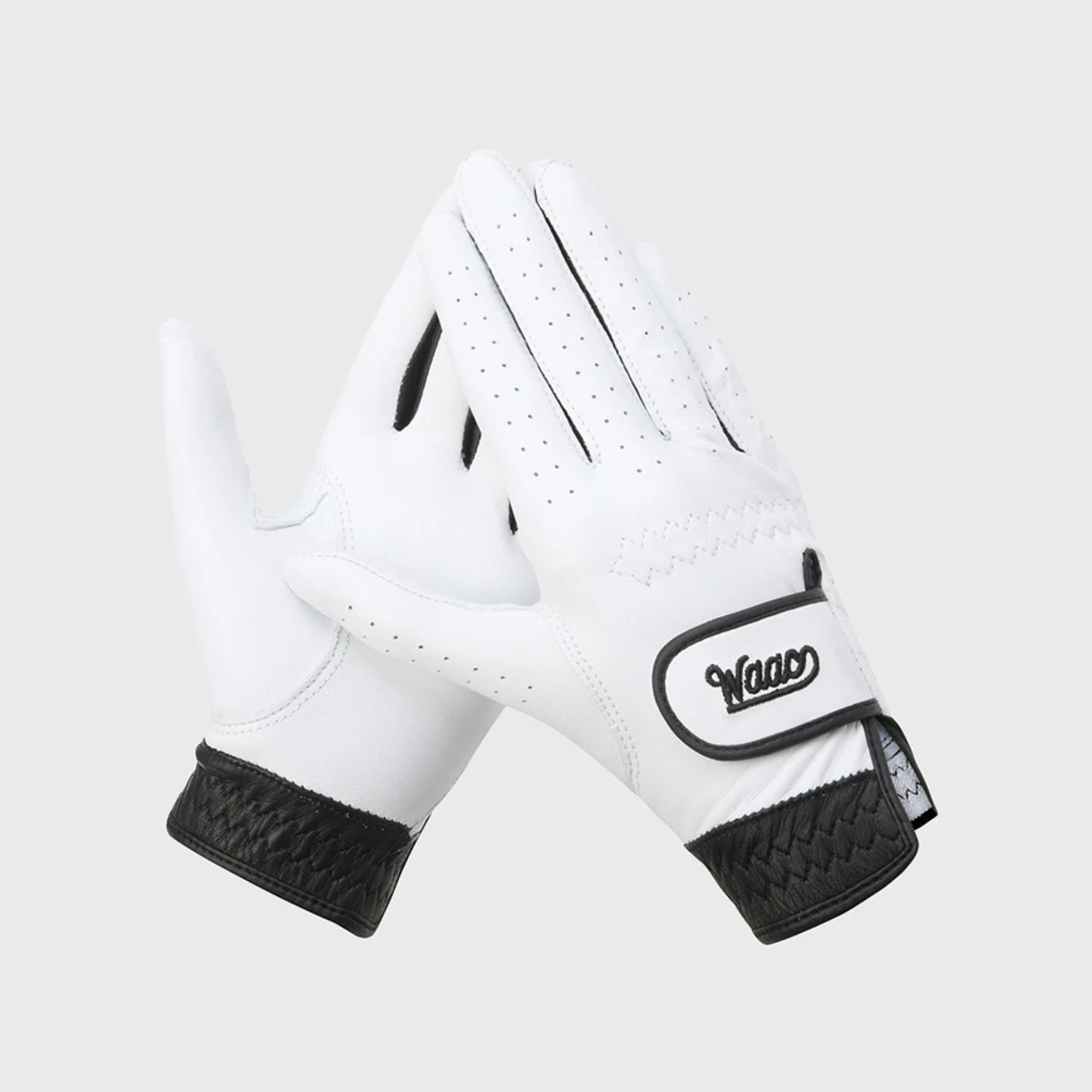 Women's Color Golf Glove in black and white featuring a premium leather design with a black textured cuff and adjustable wrist closure, shown as a pair on a light gray background.