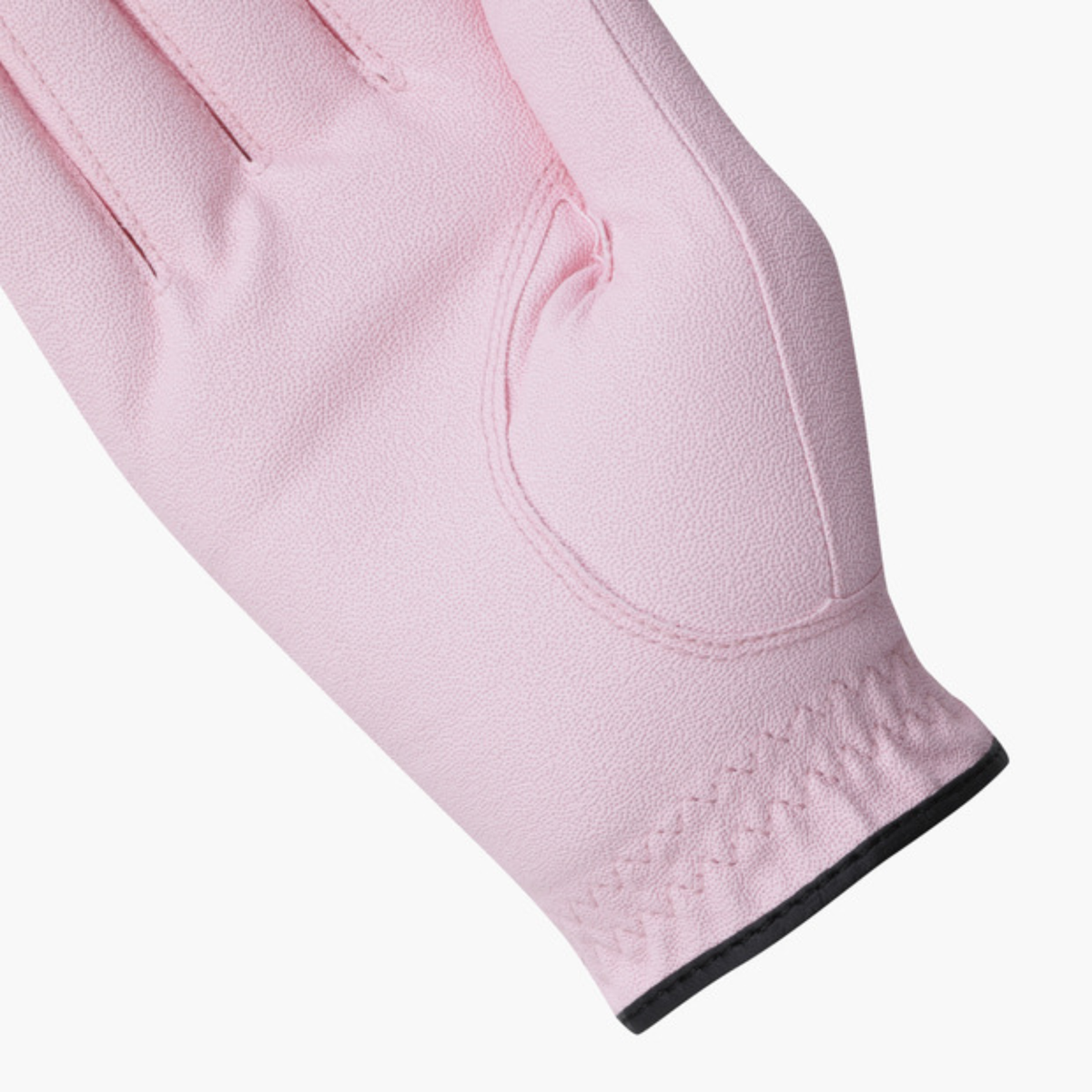 A close-up of a light pink golf glove showing the back of the hand with a black trim at the cuff, set against a plain white background.
