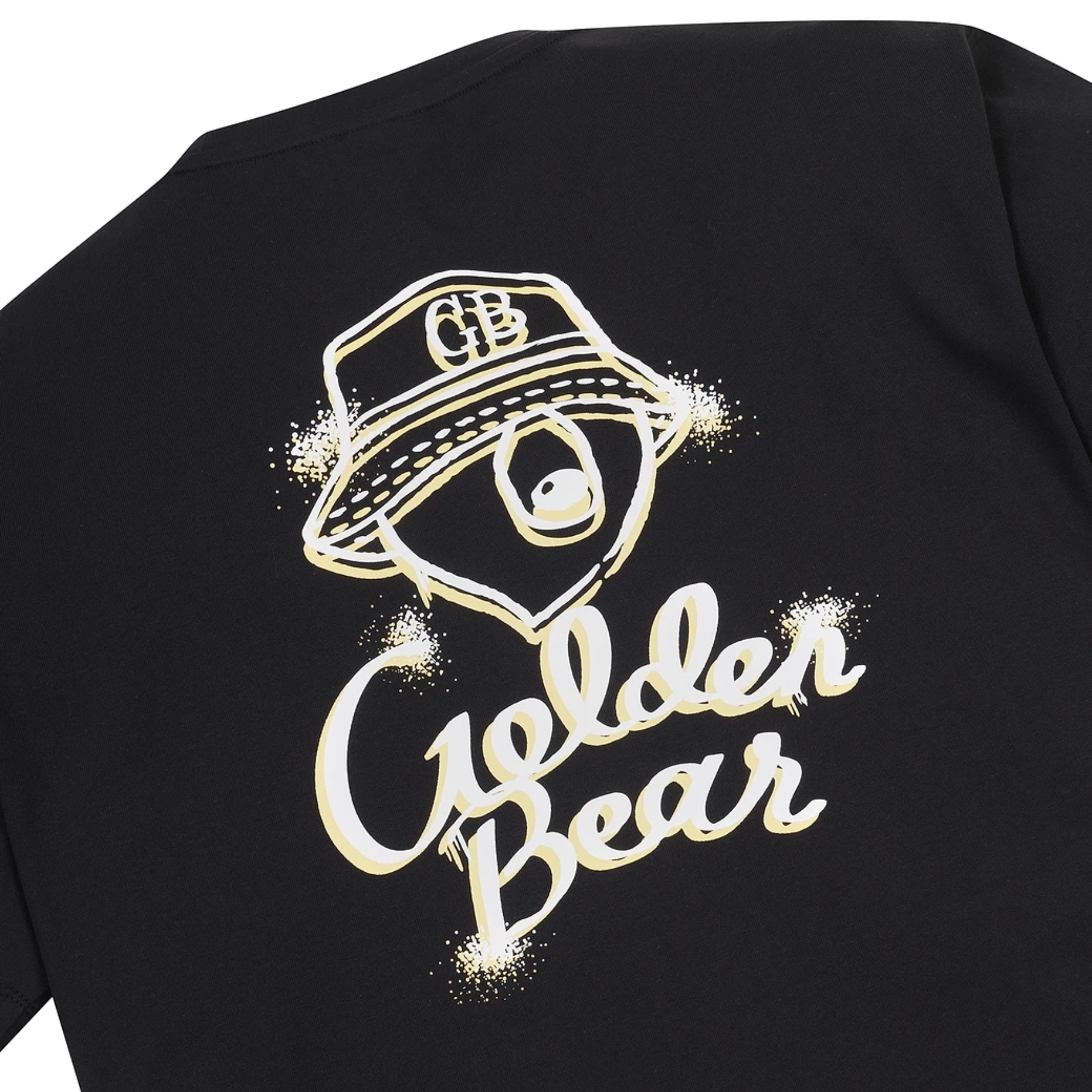 Close-up of a black t-shirt featuring a large graphic print on the front. The graphic shows a stylized golden-brown bear face wearing a bucket hat with 'GB' initials, above the words 'Golden Bear' in a white cursive font with gold glitter-like accents.