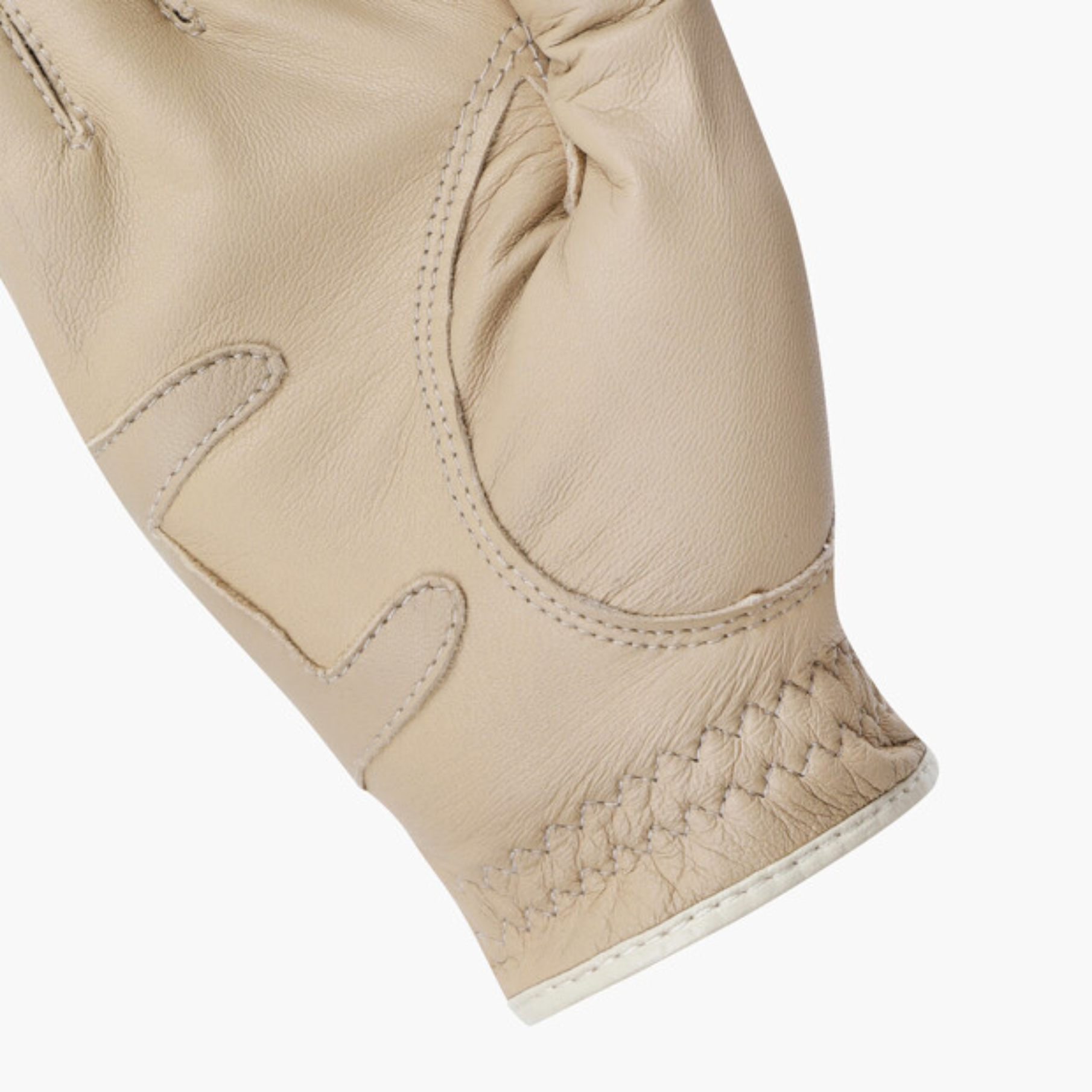 Close-up of a light beige leather glove showing the textured palm, stitched details, and a braided cuff on a white background.