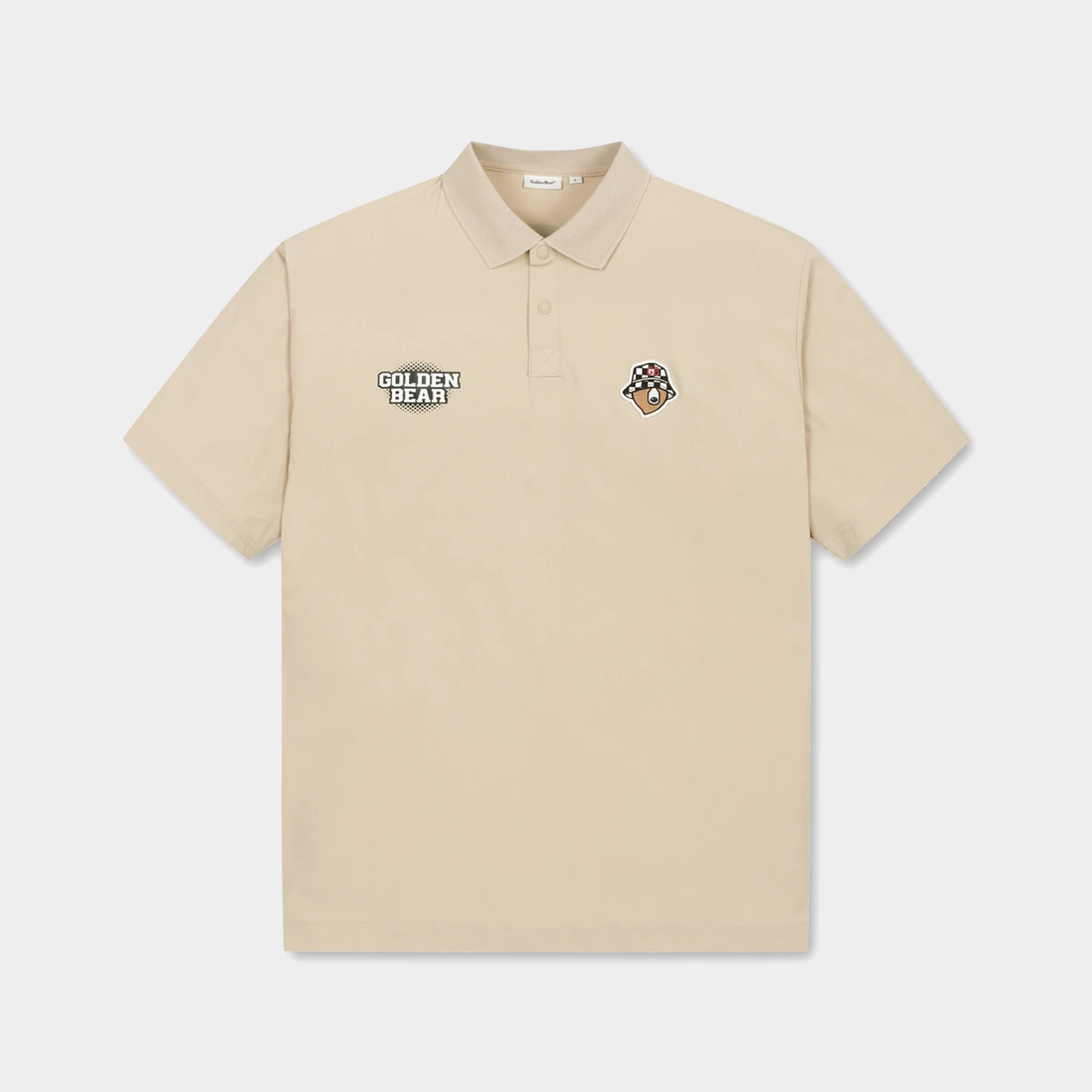 A beige short-sleeve polo shirt with a two-button placket, featuring a 'GOLDEN BEAR' patch on the left chest and a small mascot patch on the right chest, displayed on a light gray background.