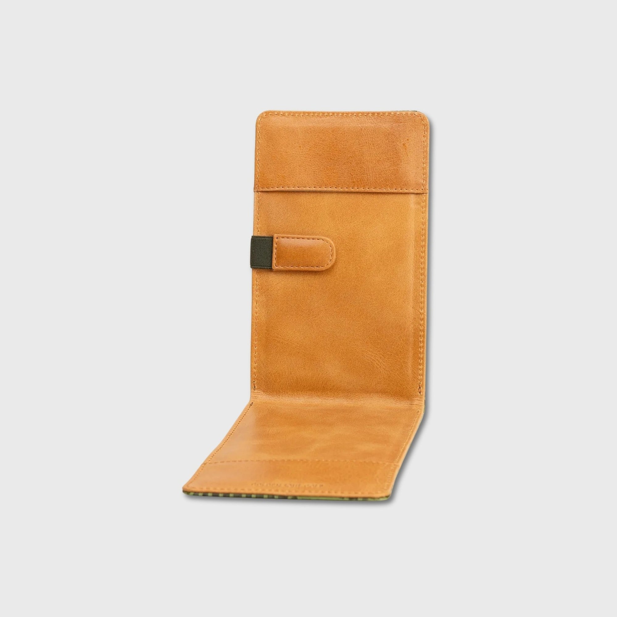 A tan yardage book holder shown open against a light gray background, featuring a small black accent tab on the front.