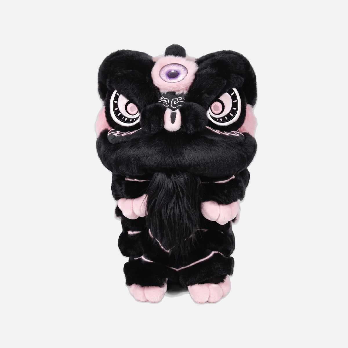 A black plush lion dance costume or character toy with pink accents, large white eyes with black outlines, and a purple eye patch, centered on a light gray background.